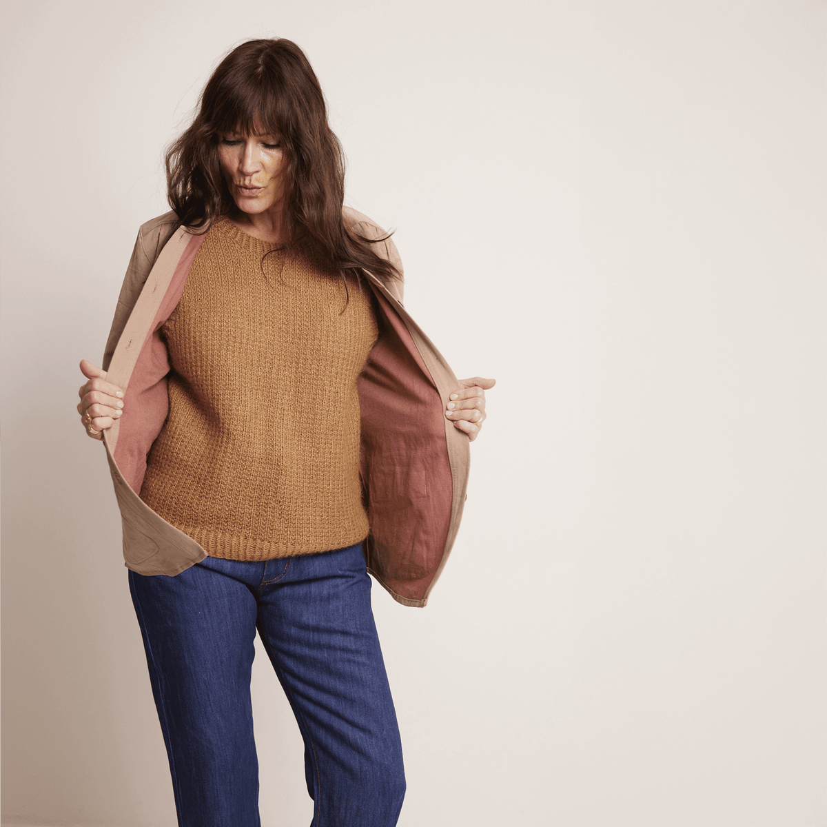 Woman wearing a relaxed Artist Jacket Paper Pattern over a brown sweater, showcasing its casual workwear design.