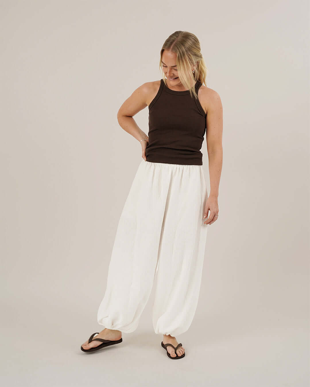 Model wearing Bubble Pants sewing pattern in white with a dark tank top, showcasing voluminous, elasticated pants.