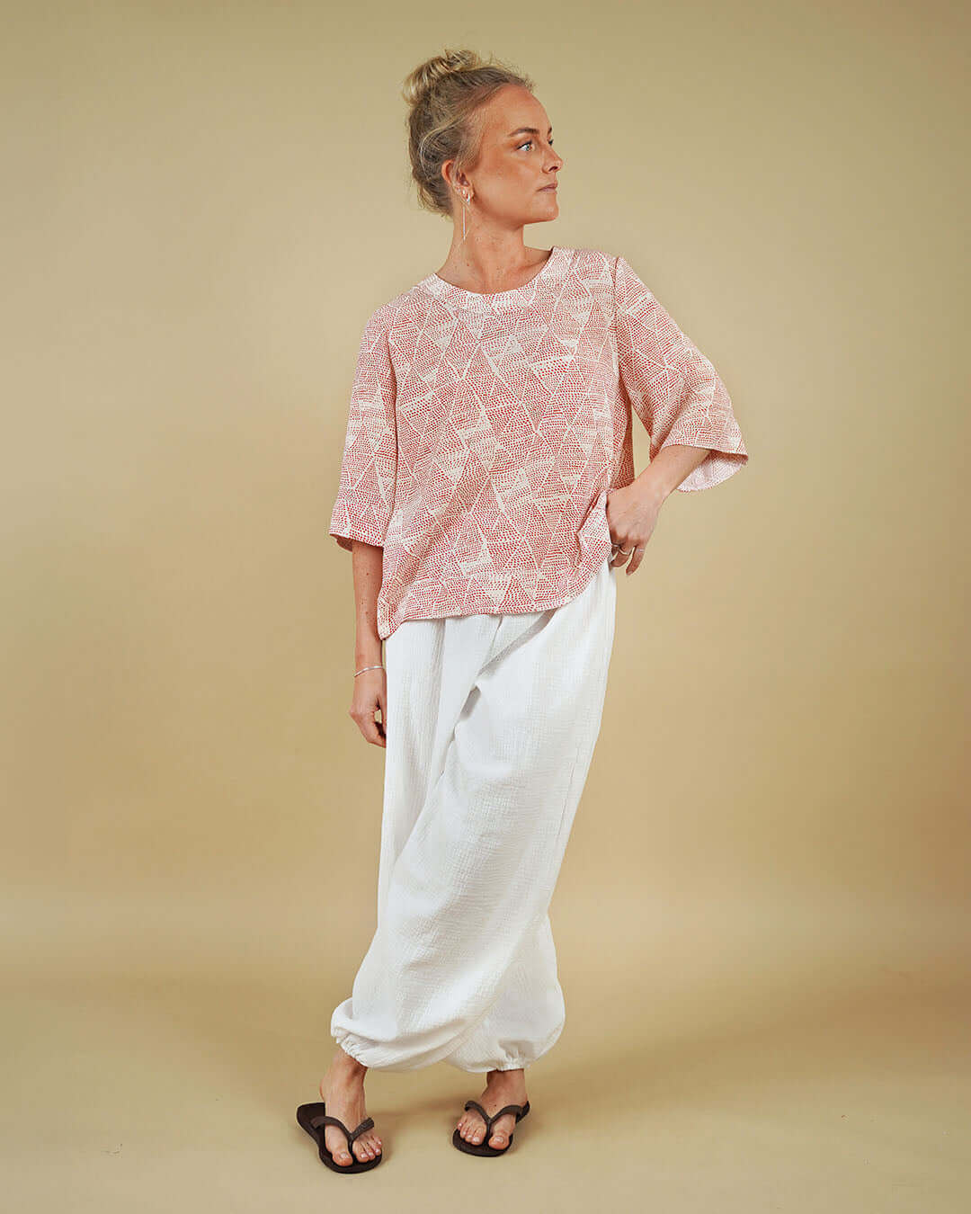 Woman modeling Bubble Pants sewing pattern with a geometric top against a plain background.