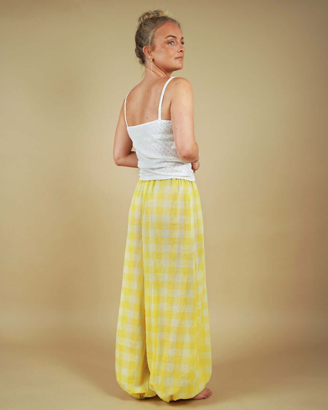 Back view of a model wearing yellow plaid Bubble Pants sewing pattern with a simple white top.