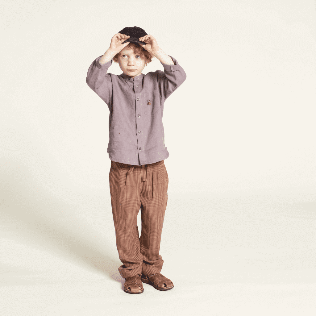 Kid wearing Mini Jensen Shirt sewing pattern, styled with mKids Volume pants sewing pattern and a hat.