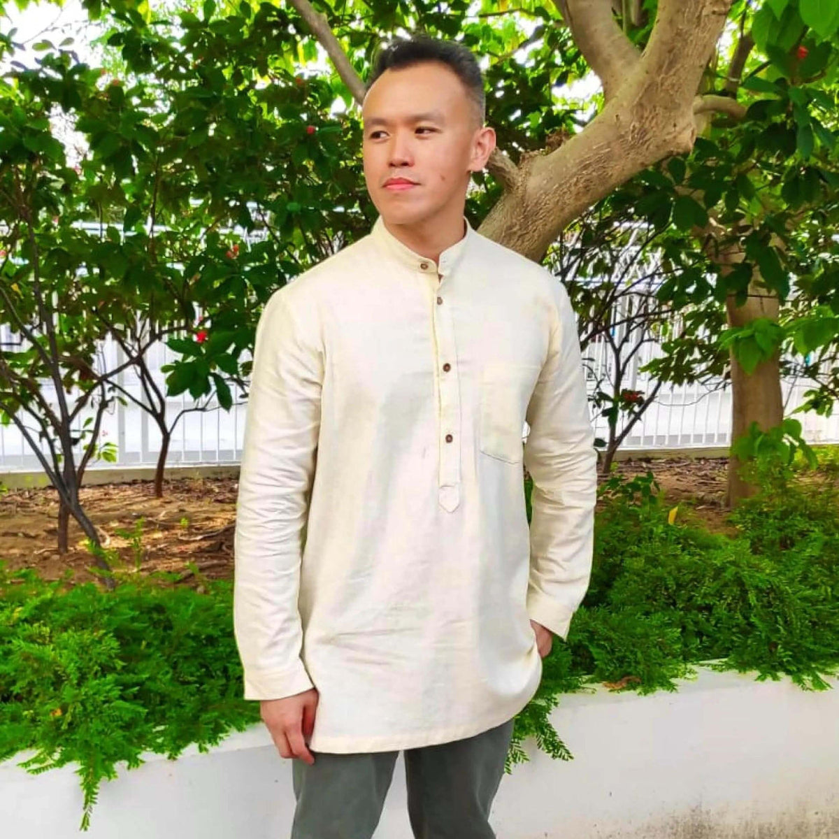 Men's Tunic paper pattern showcased on a model in a garden, featuring a banded collar and button placket.