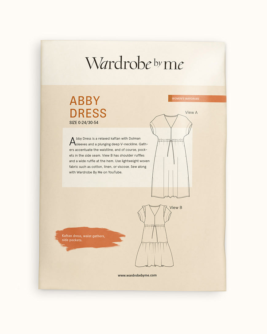 Abby Dress Paper Pattern packaging featuring a kaftan-style dress design with Dolman sleeves and side pockets.