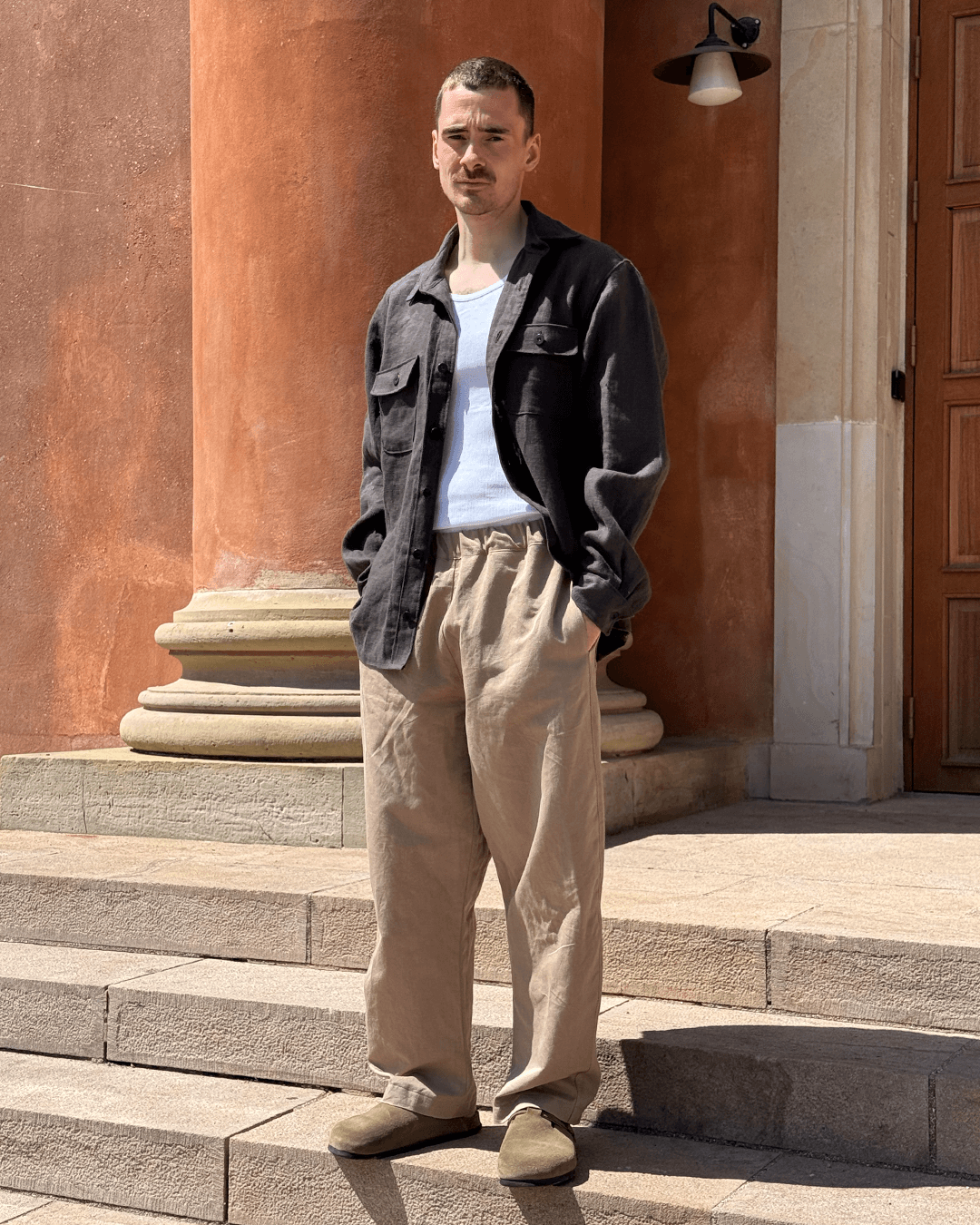 Man wearing Volume Pants Sewing Pattern, unisex pull-on pants with elastic waist and pockets, standing outdoors.