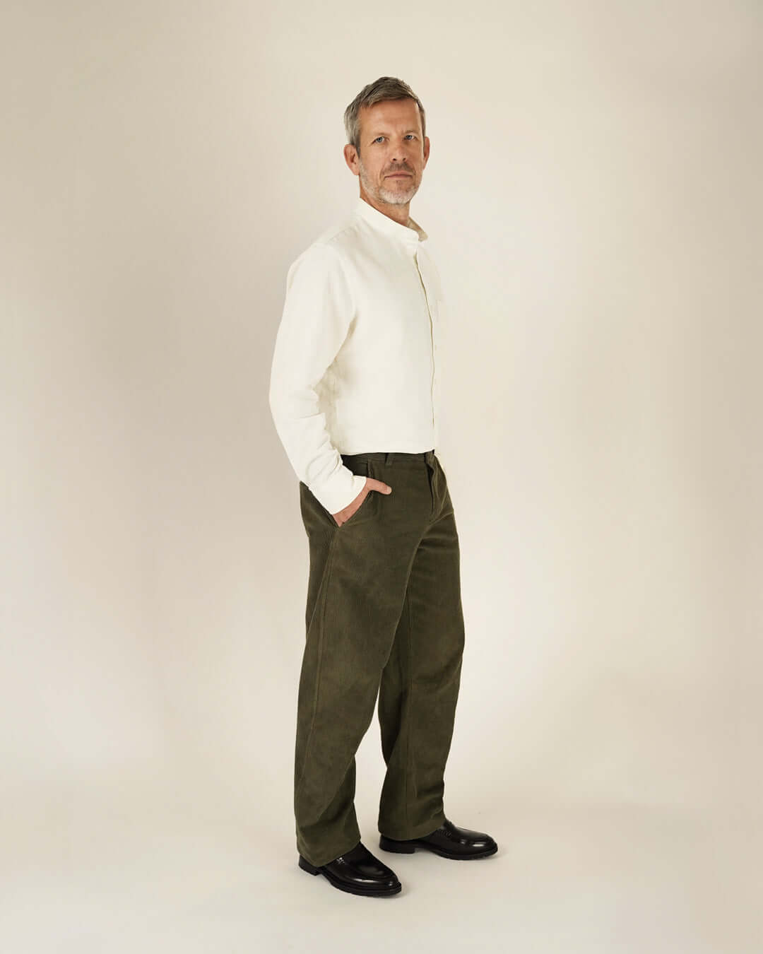 Model wearing the Jensen shirt Paper Pattern, a white button-up shirt paired with olive corduroy pants.