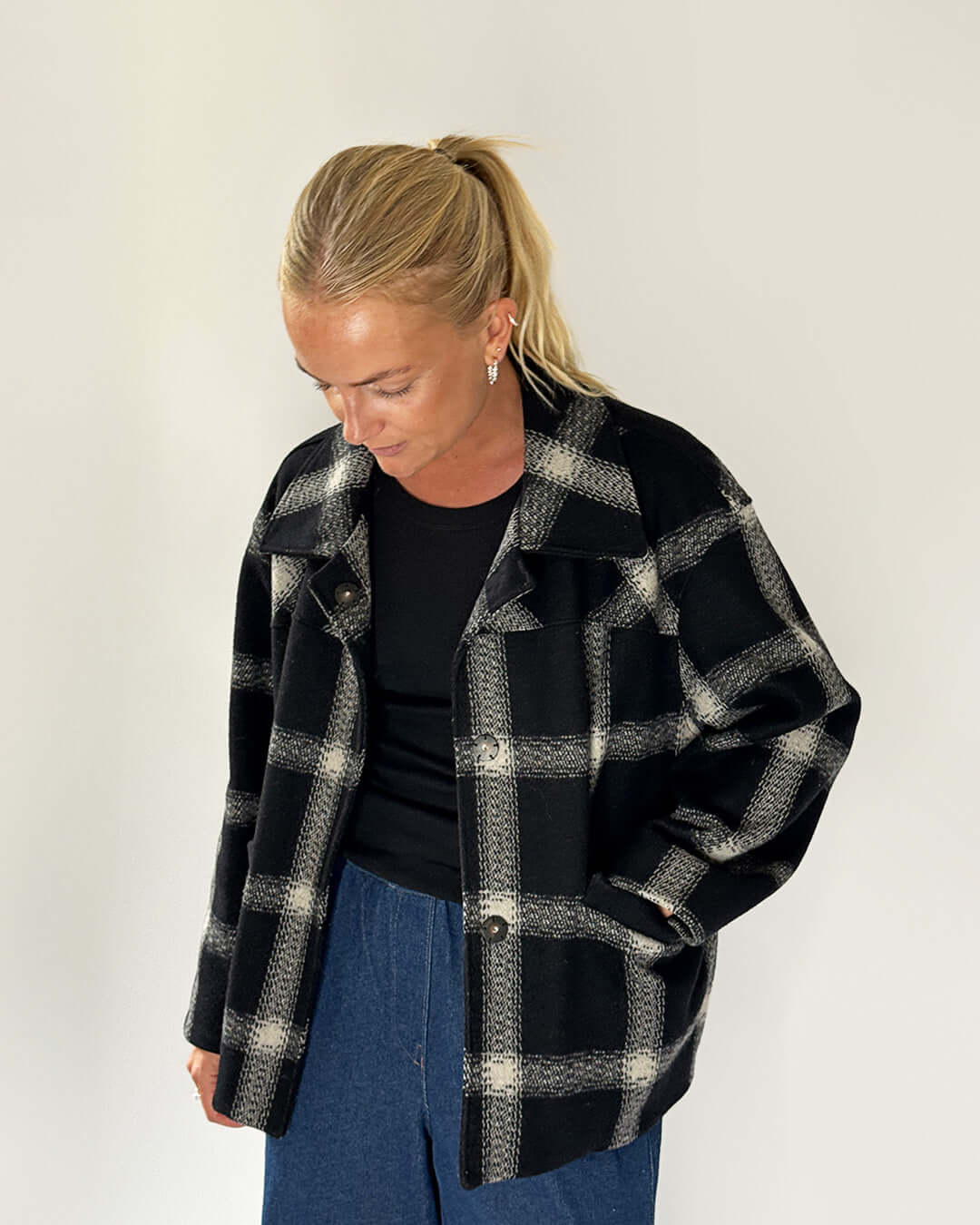 Woman wearing a stylish black and white plaid Car Coat Sewing Pattern, showcasing a relaxed fit and comfortable style.