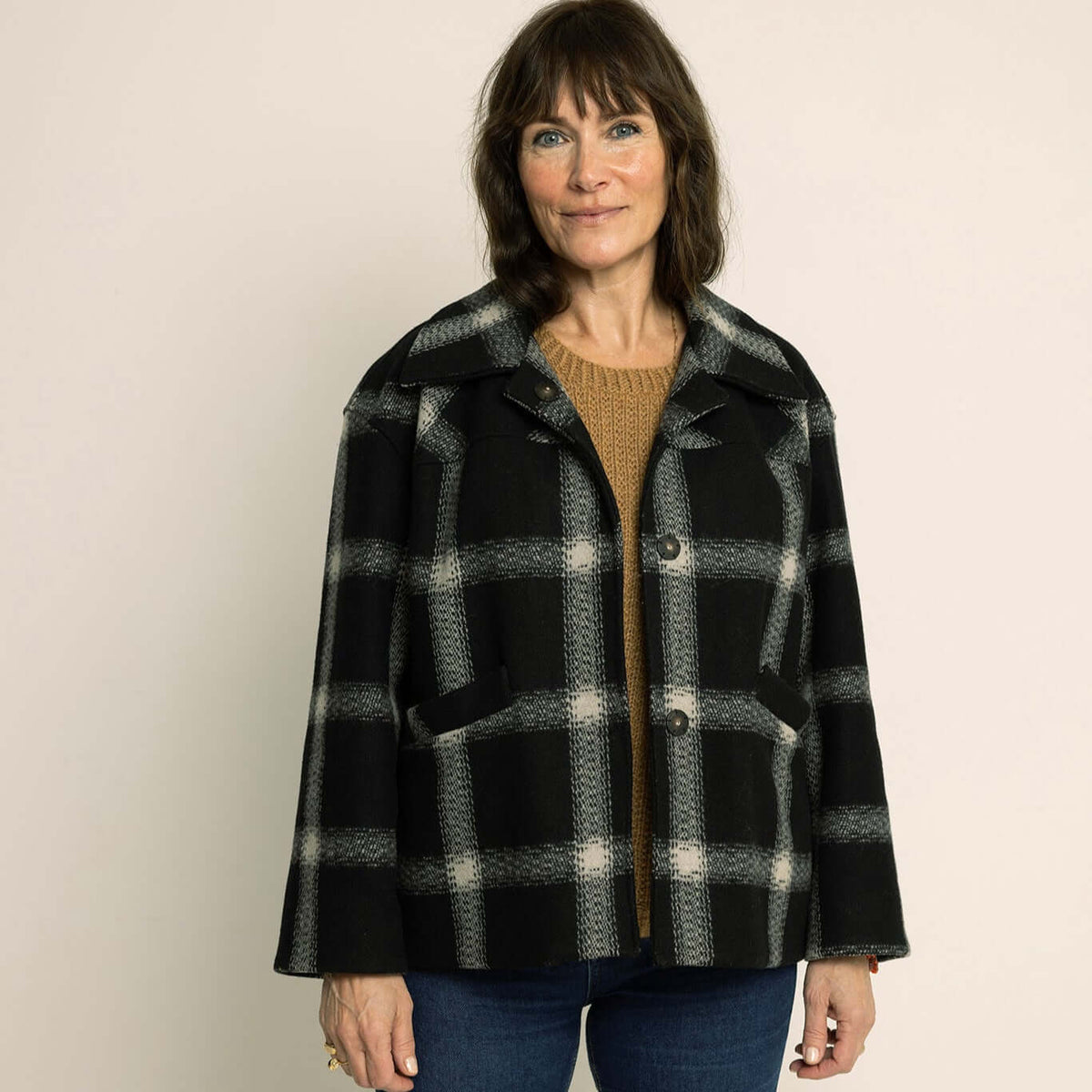 Model wearing Car Coat Sewing Pattern in a black and white plaid design, showcasing a stylish and relaxed fit.