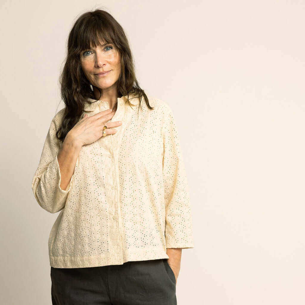 Model wearing a relaxed-fit Dukke Blouse Paper Pattern in light fabric with a Peter Pan collar and 3/4-length sleeves.