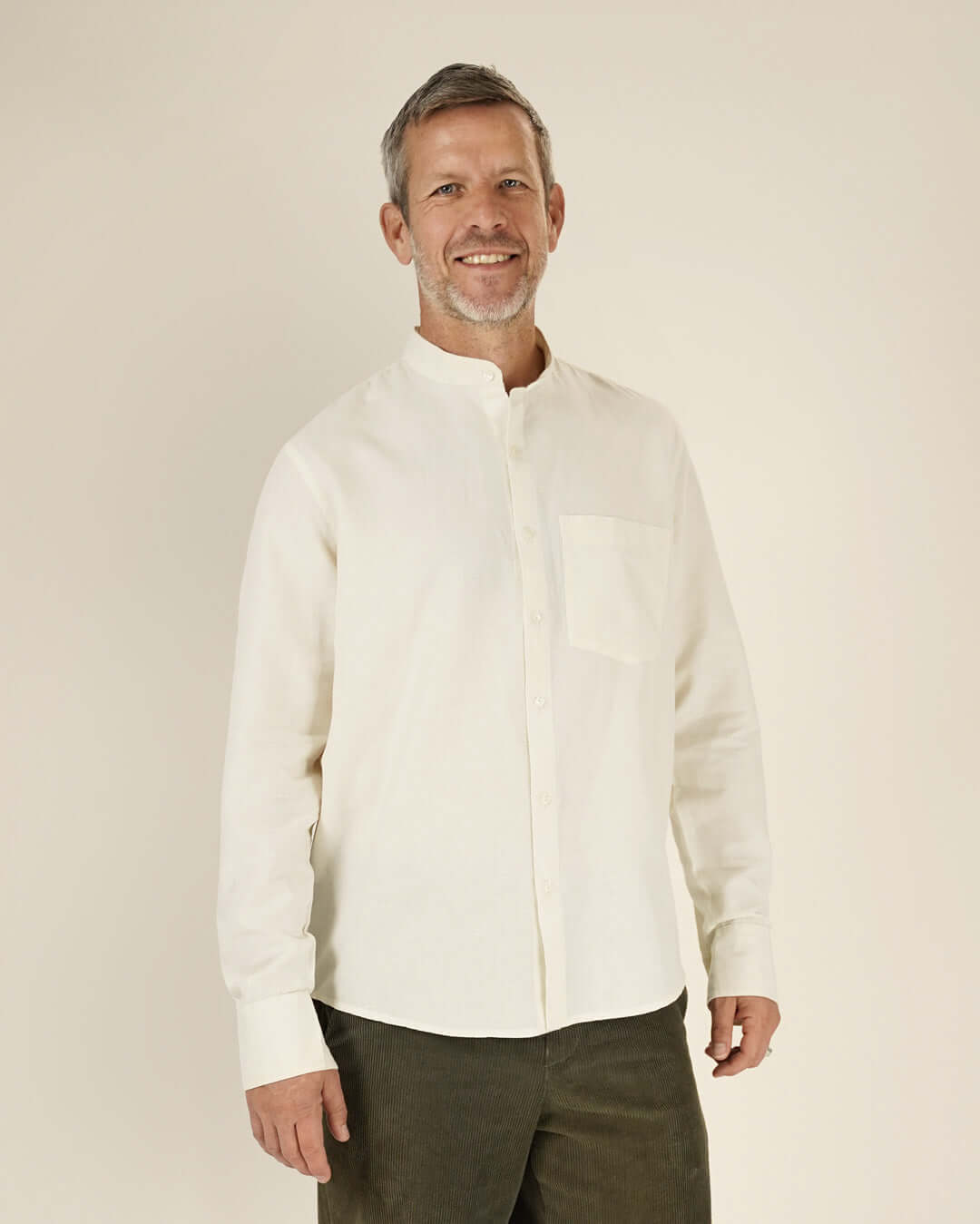 Jensen shirt Paper Pattern model wearing a cream button-up shirt with a classic collar and front pocket.