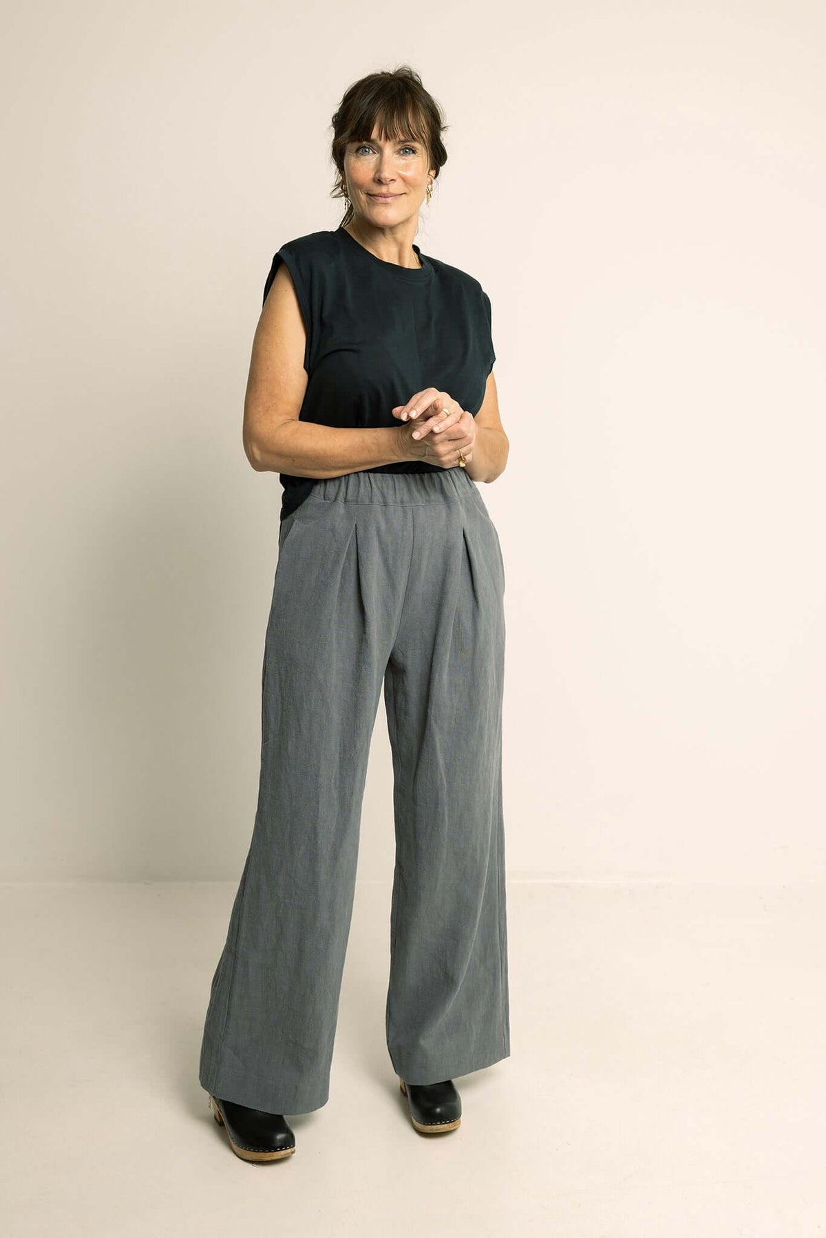 Woman wearing Palazzo Pants Paper Pattern with wide legs, deep front pleats, and an elastic waistline.