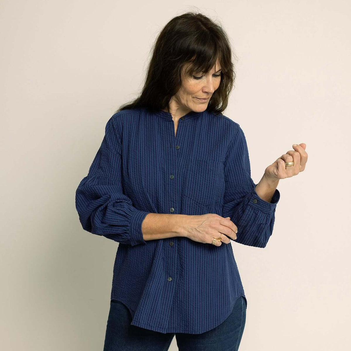 Woman wearing a Puff Shirt Paper Pattern, a stylish navy blouse with gathered sleeves and a flat collar.