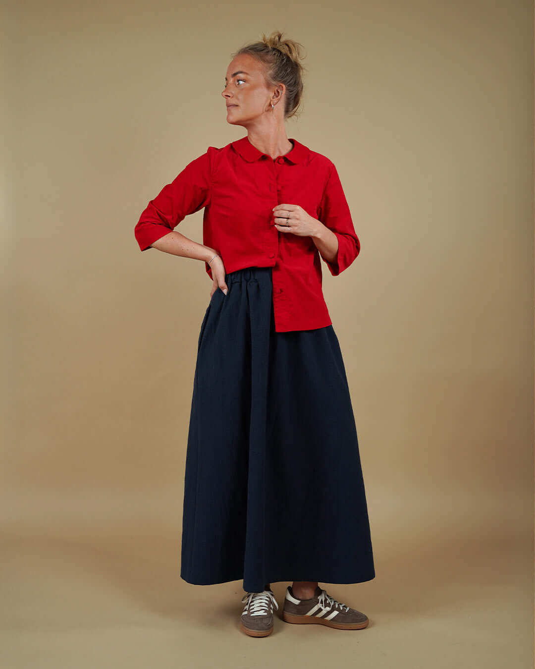 Woman wearing the Dukke Blouse and Claude Skirt sewing pattern, front three-quarter view