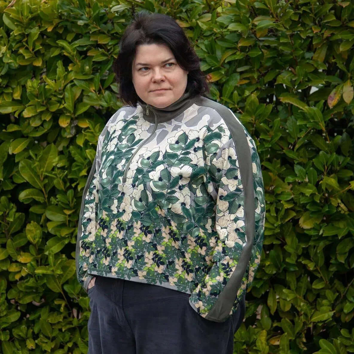 Half-Zipper Sweater Paper Pattern model showcasing stylish floral design with a sporty collar against a green background.