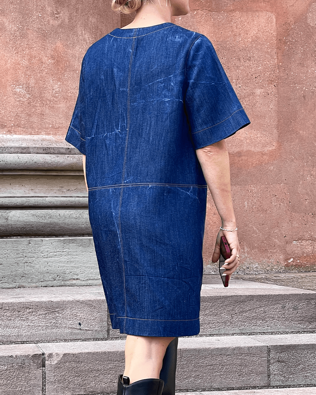 City Dress Sewing Pattern displayed from the back, featuring a denim fabric and elbow-length wide sleeves.