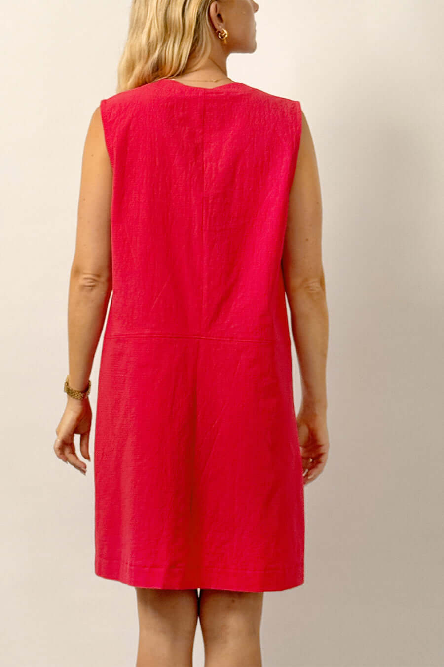 Back view of a woman wearing a sleeveless pink dress from the City Dress Sewing Pattern.
