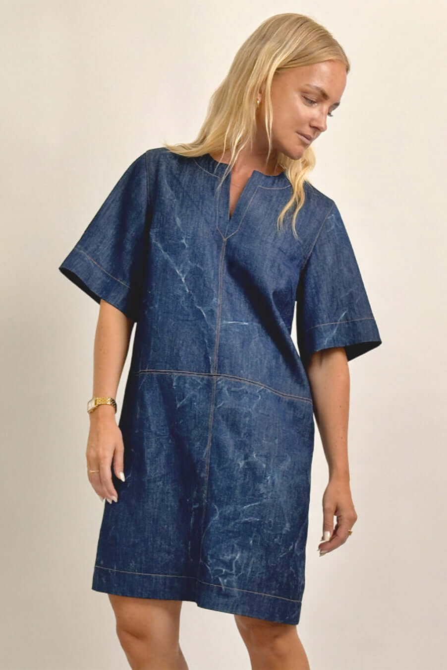 Model wearing City Dress Sewing Pattern in denim with elbow-length sleeves and notched neckline.