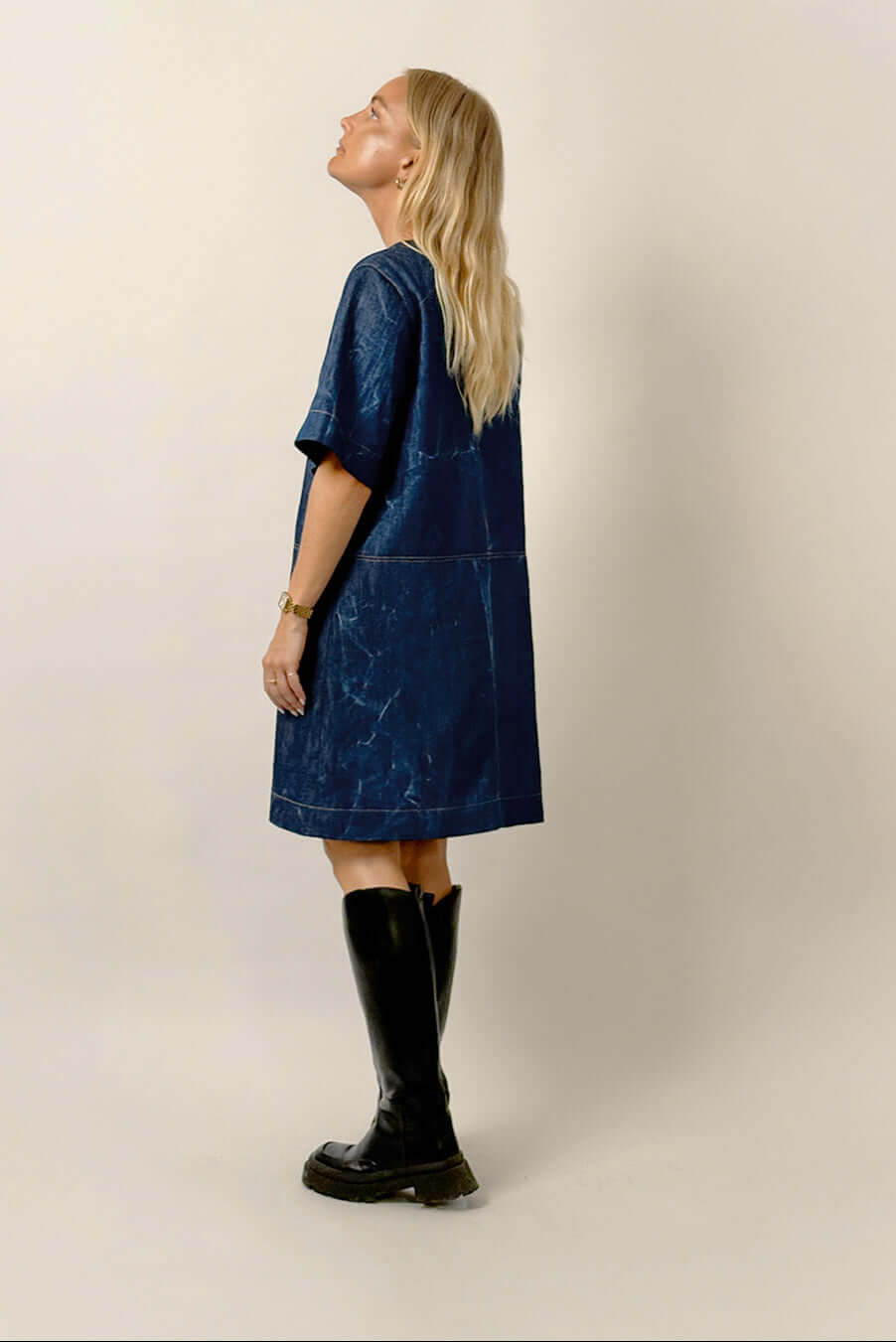 Model wearing the City Dress Sewing Pattern, a modern dress with elbow-length sleeves and notched neckline, styled elegantly.