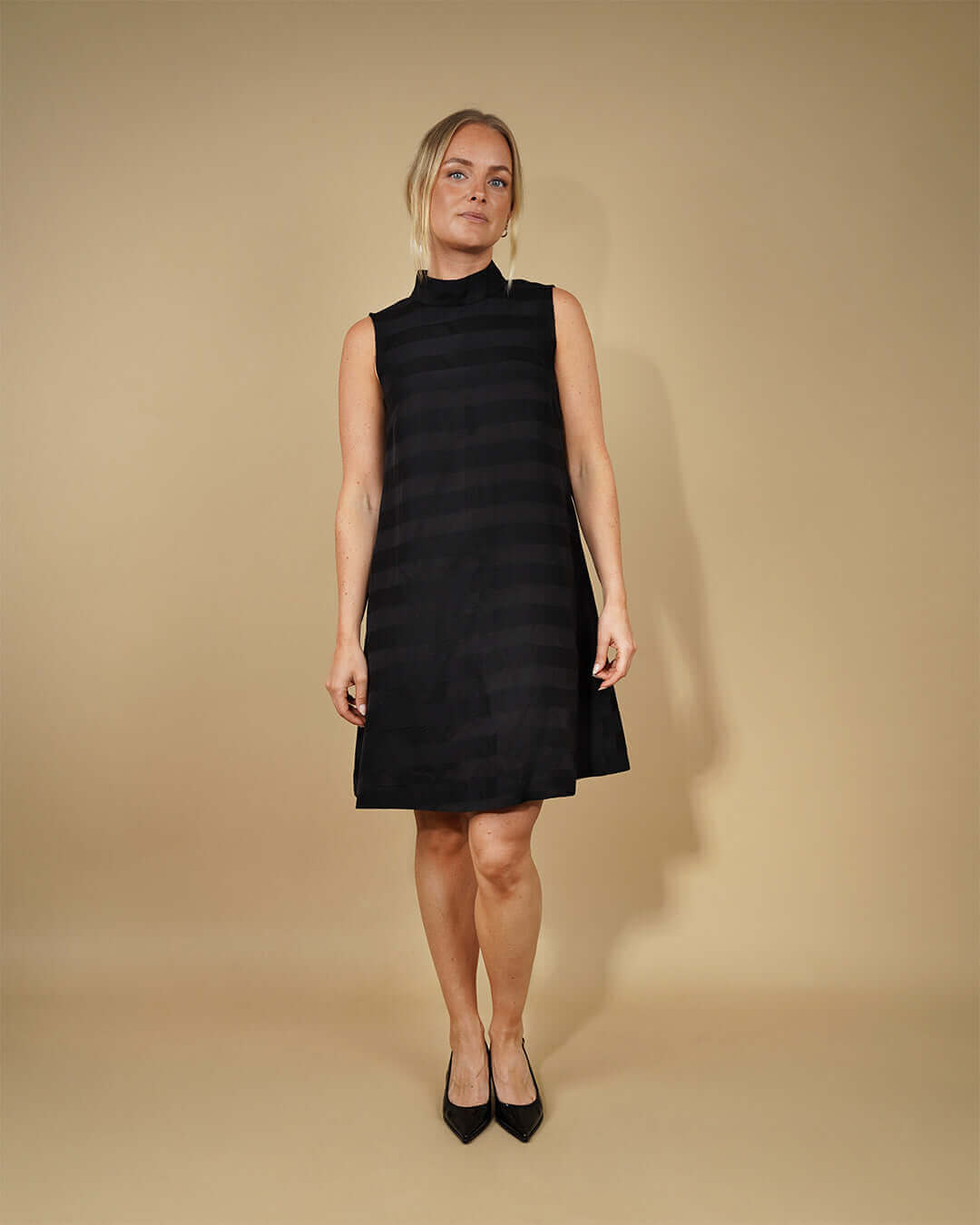 Model wearing the June Dress Paper Sewing Pattern in a black sleeveless A-line dress.