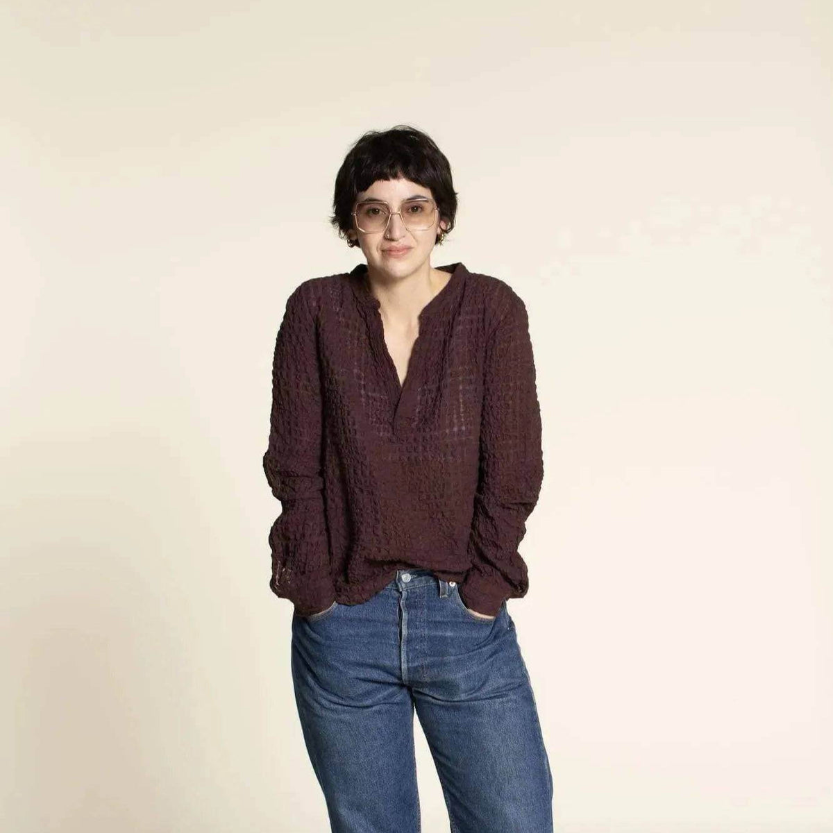 Model wearing a relaxed Perfect Tunic Paper Pattern top in dark color, paired with jeans, showcasing a casual style.
