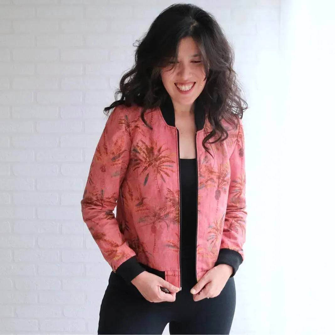 Woman wearing a floral bomber jacket made from the Bomber Jacket Paper Pattern, showcasing its unique design and sporty look.