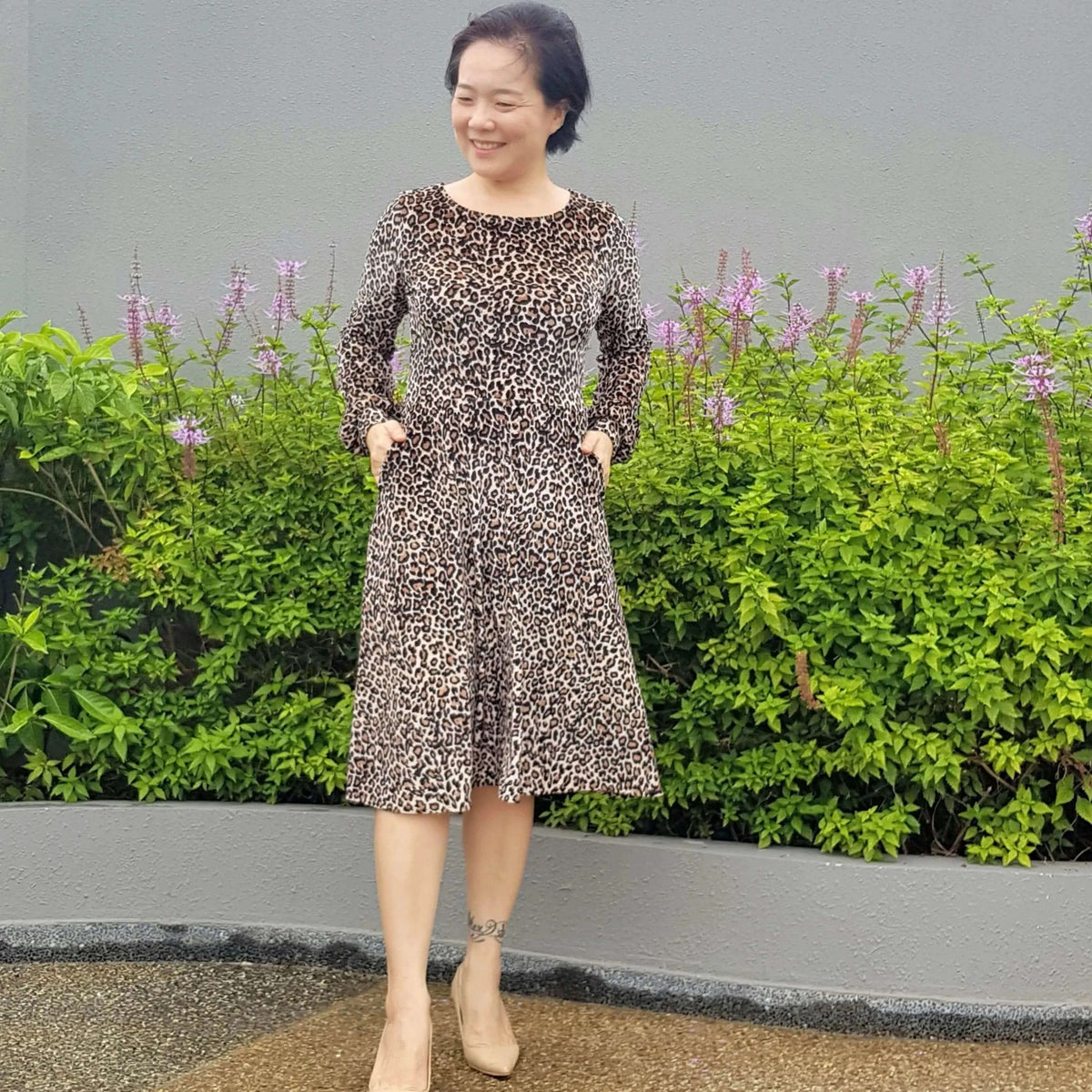 Asta dress Paper Pattern worn by a woman, featuring a leopard print design and semi-circular A-line skirt.