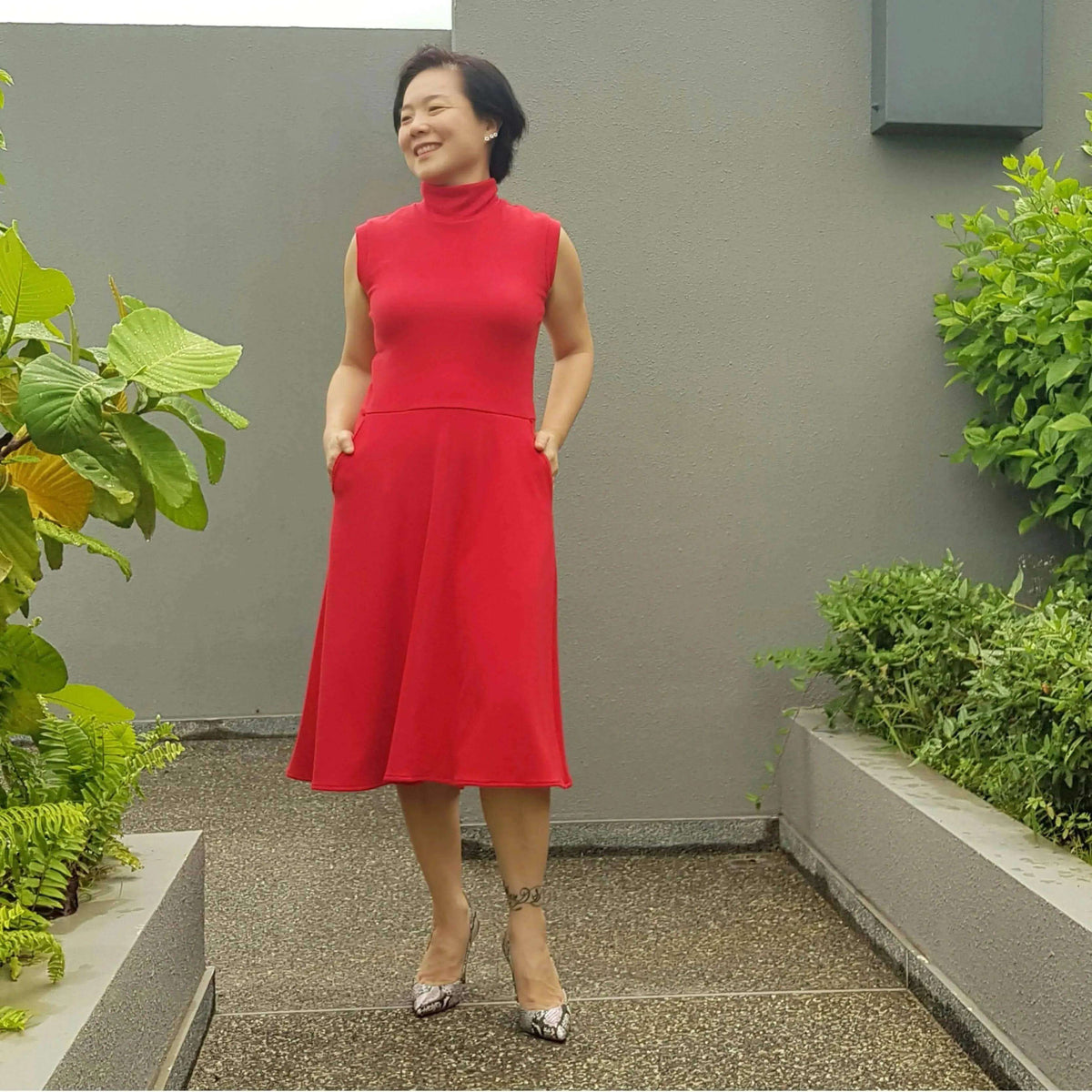 Asta dress Paper Pattern modeled in red with a fitted bodice and A-line skirt, perfect for versatile styling options.
