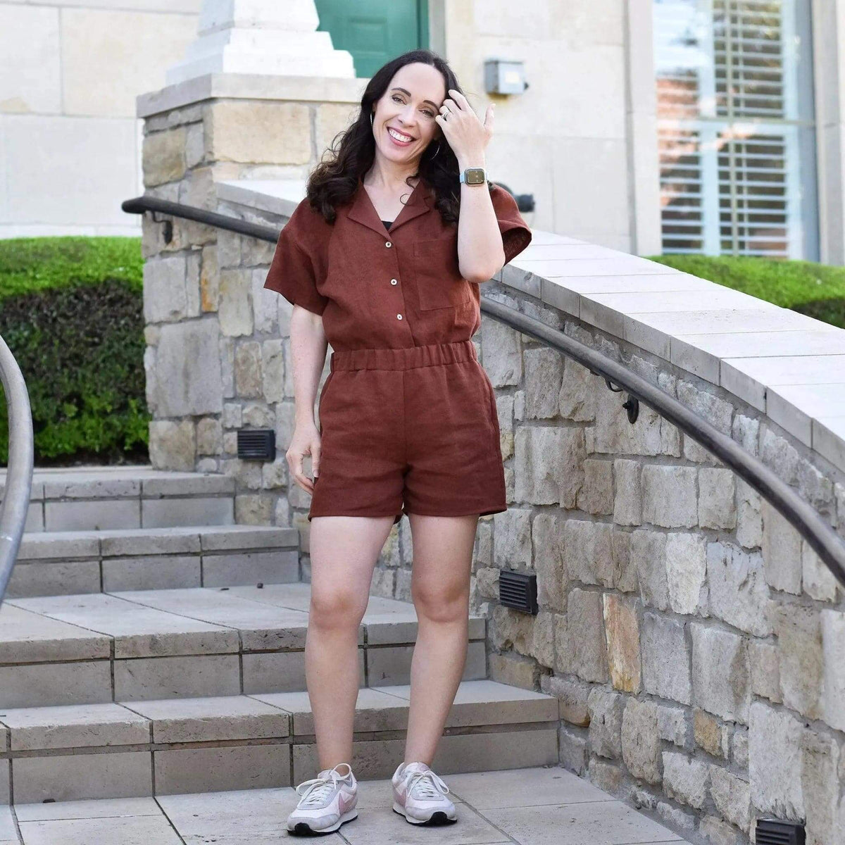 Woman wearing a Camp Shirt and shorts Paper Pattern posing on stairs, showcasing a boxy shirt and elasticated shorts.