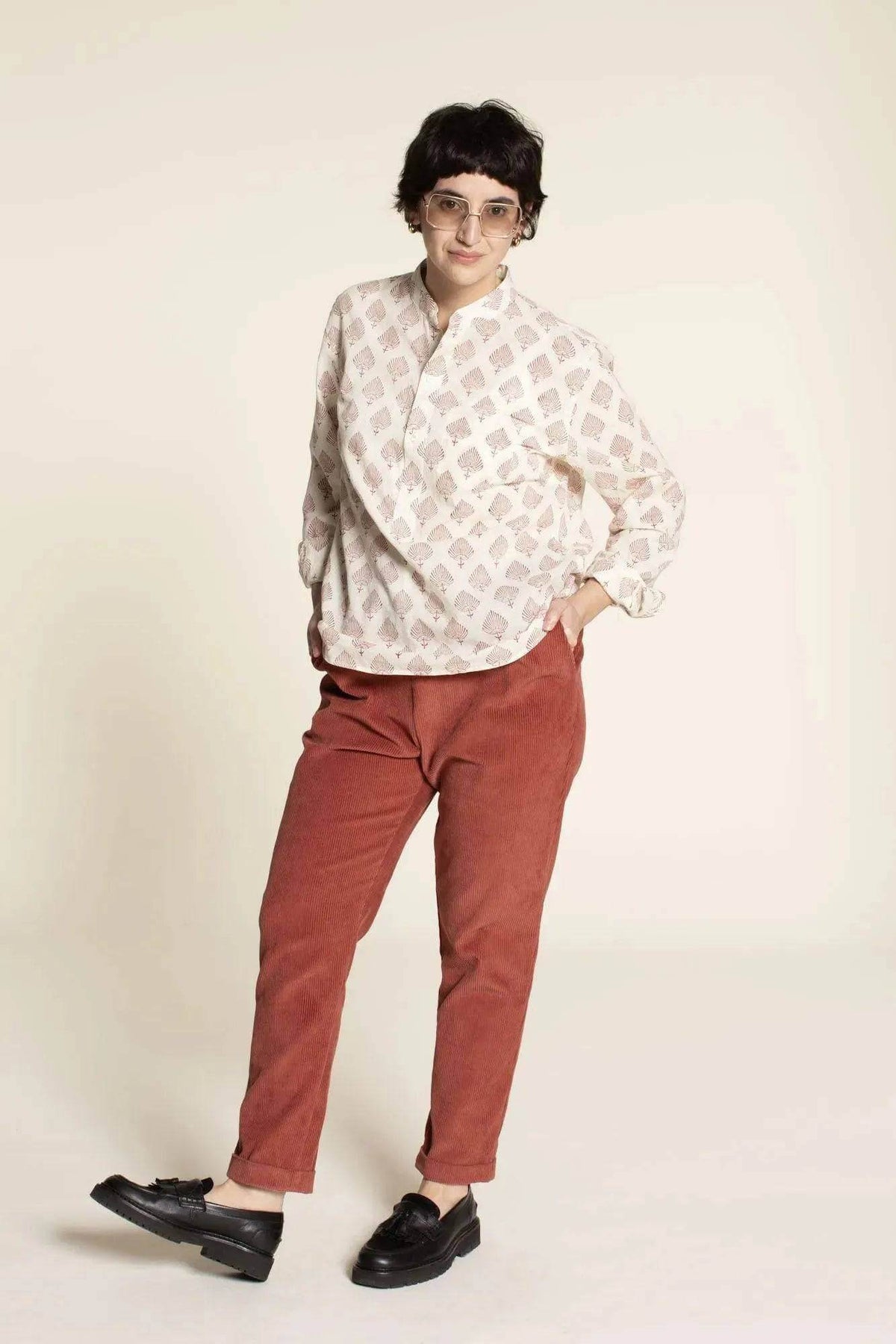 Model wearing Easy Pants Paper Pattern in rust color, paired with a white blouse, showcasing a stylish and comfortable outfit.