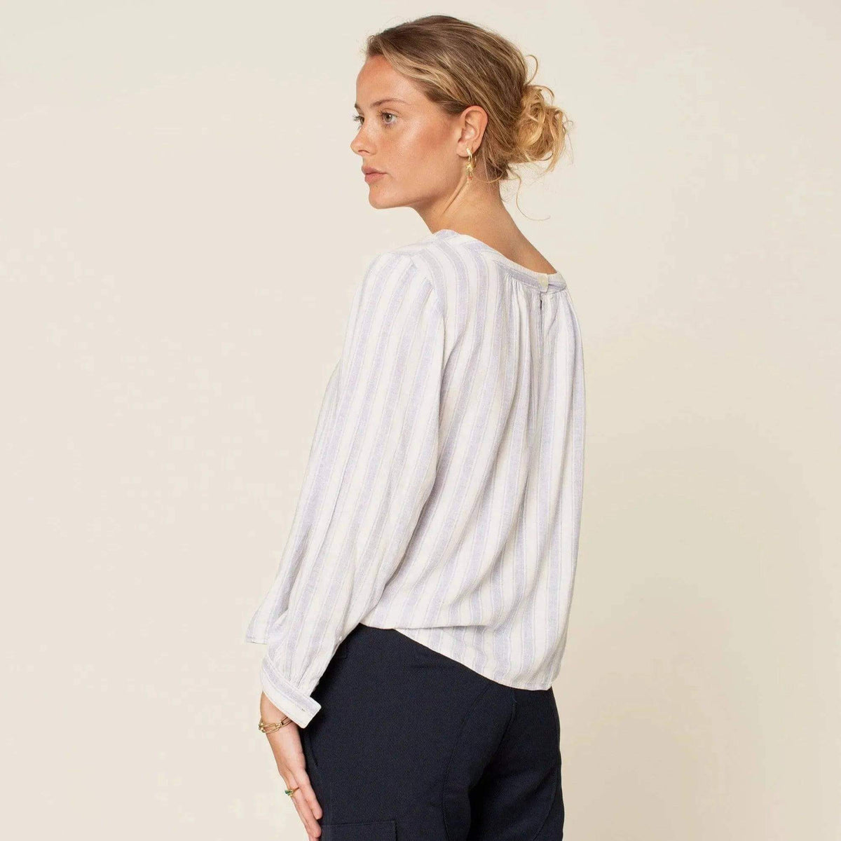 Esther Blouse Paper Pattern shown from the back, featuring a button and slit at the neckline and gathered sleeves.