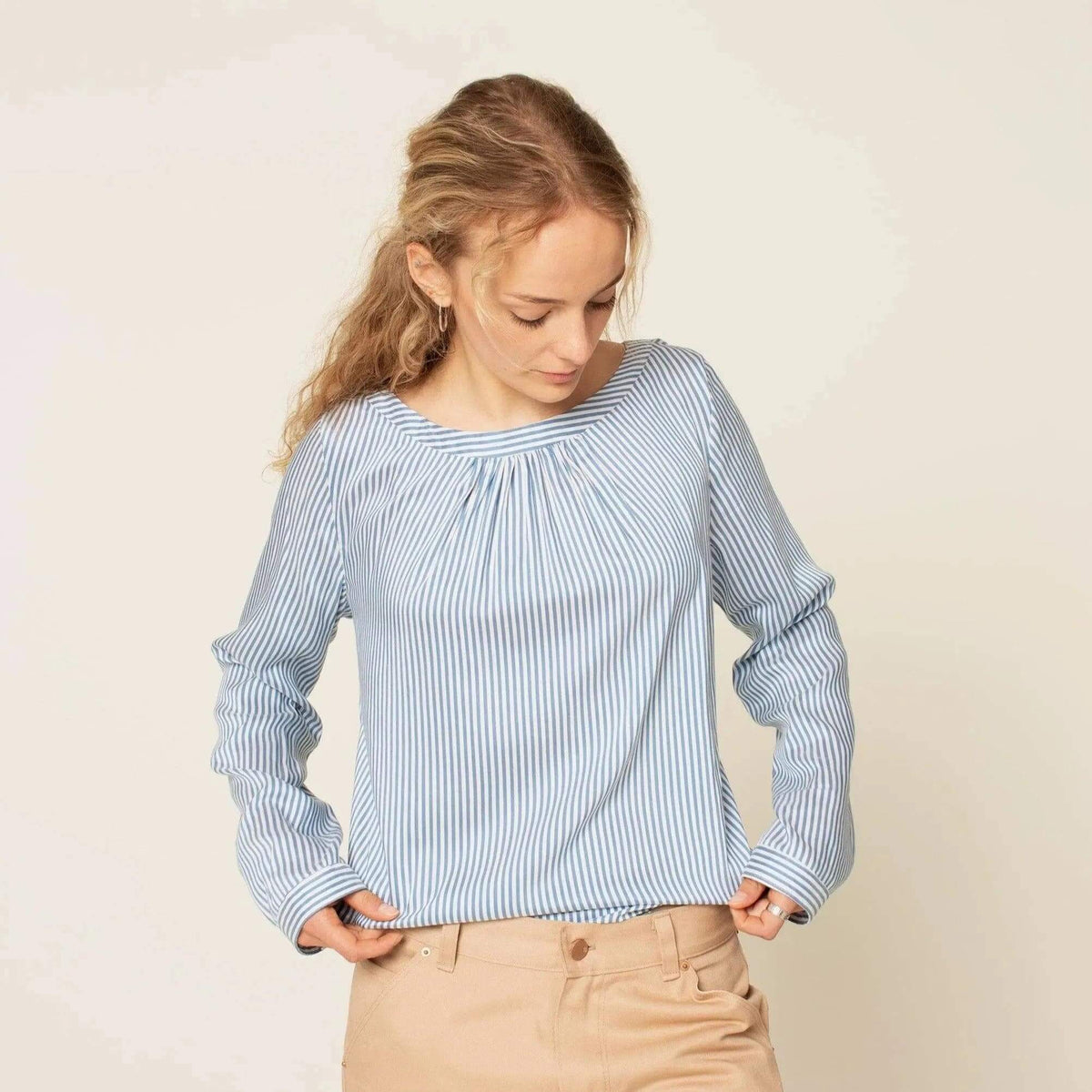 Esther Blouse Paper Pattern showcasing a striped blouse with pleats and long sleeves, perfect for feminine style.