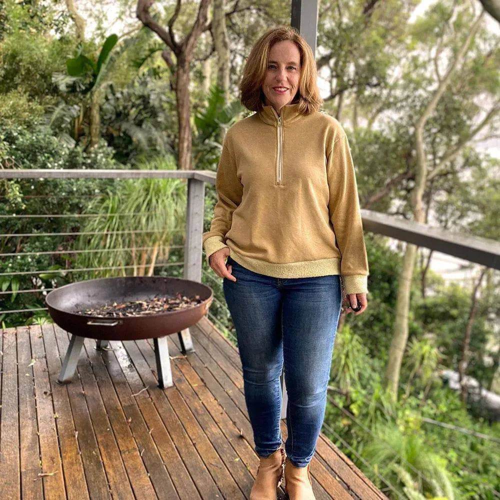 Half-Zipper Sweater Paper Pattern showcased by a woman in a cozy outdoor setting with a fire pit.
