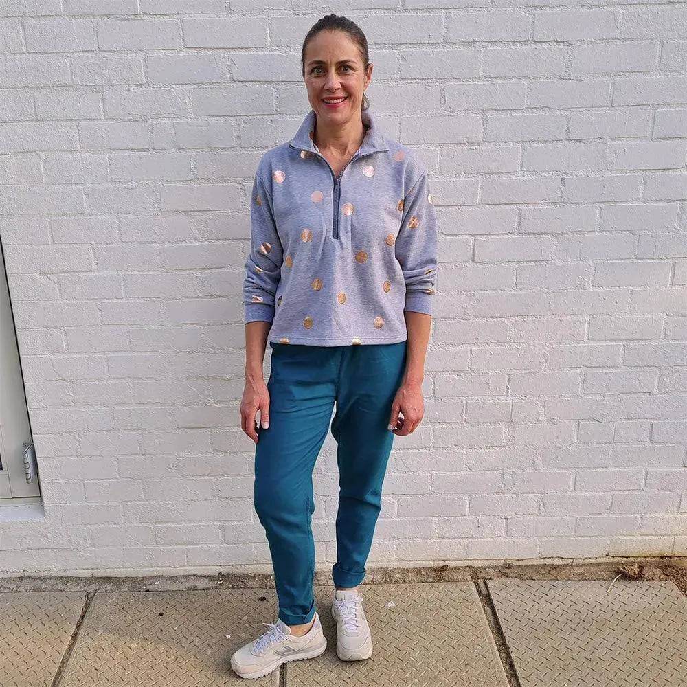 Half-Zipper Sweater Paper Pattern worn by a woman standing against a white wall, featuring a sporty design with polka dots.
