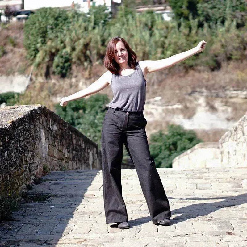 Model wearing Hepburn Pants Paper Pattern standing on stone steps in a natural setting.