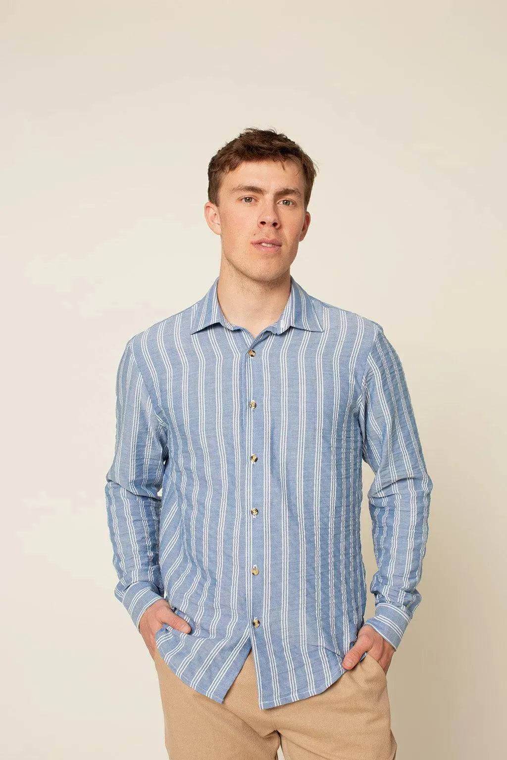 Jensen shirt Paper Pattern model wearing a blue striped button-up shirt with cuffed sleeves.