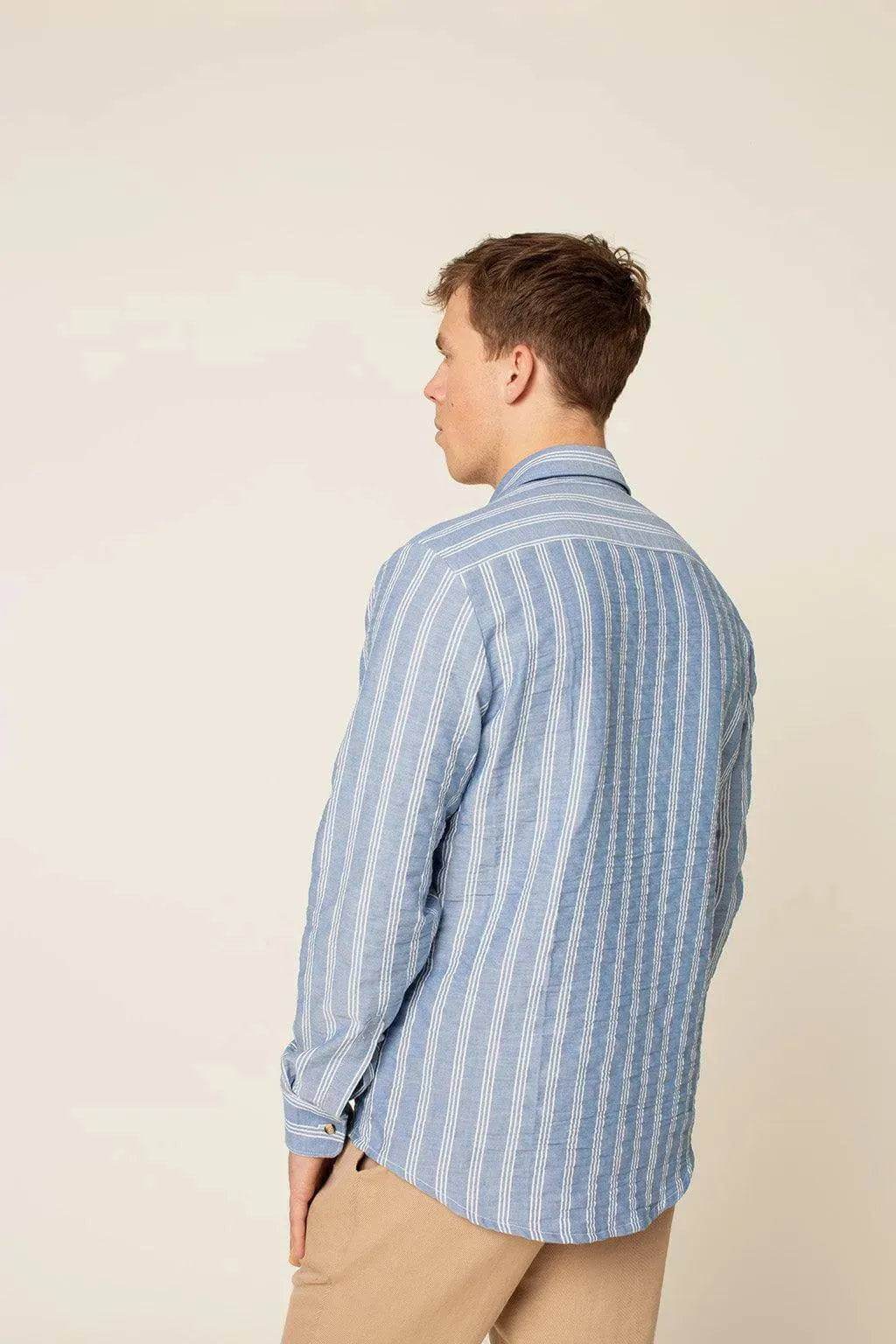 Back view of a model wearing the Jensen shirt Paper Pattern, featuring blue stripes and a relaxed fit.