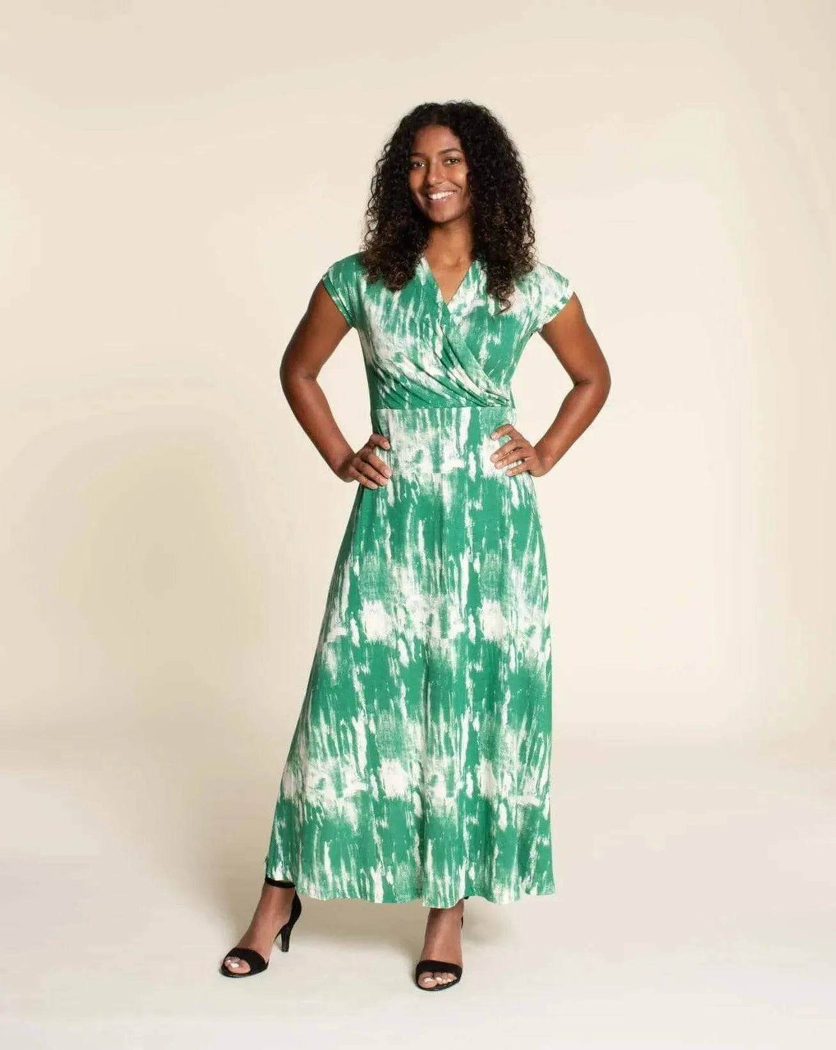 Model wearing the Mirri Dress Paper Pattern in a green tie-dye print, featuring a shawl collar and A-line skirt.