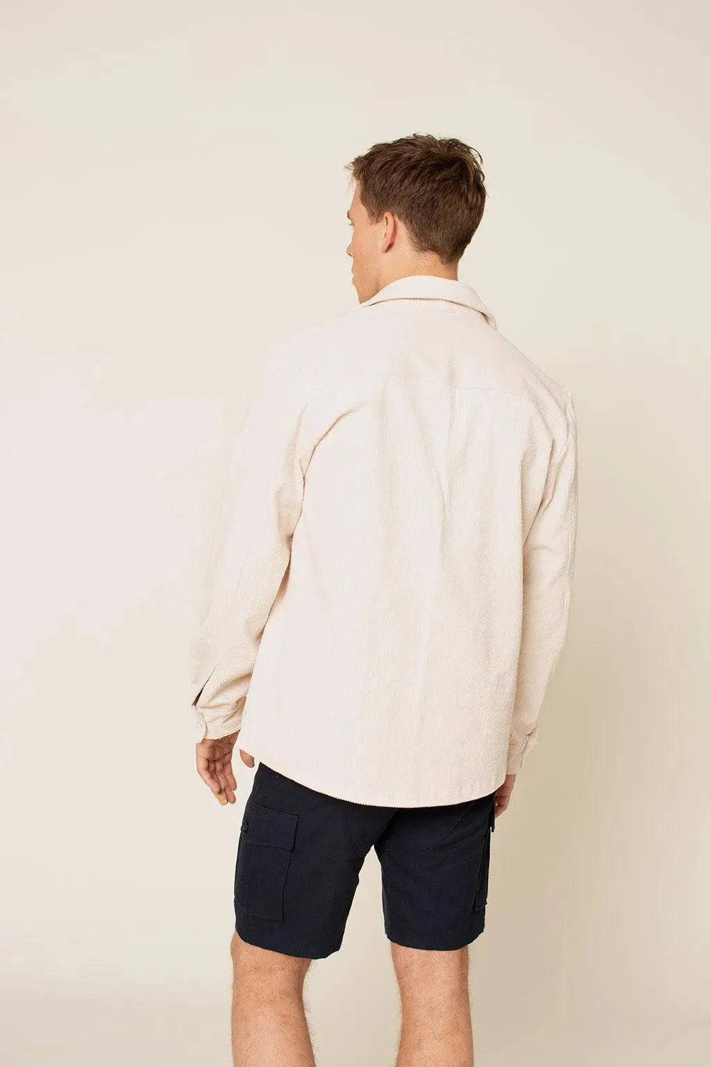 Back view of a man wearing an Overshirt Jacket Paper Pattern with cuffed sleeves and shorts.