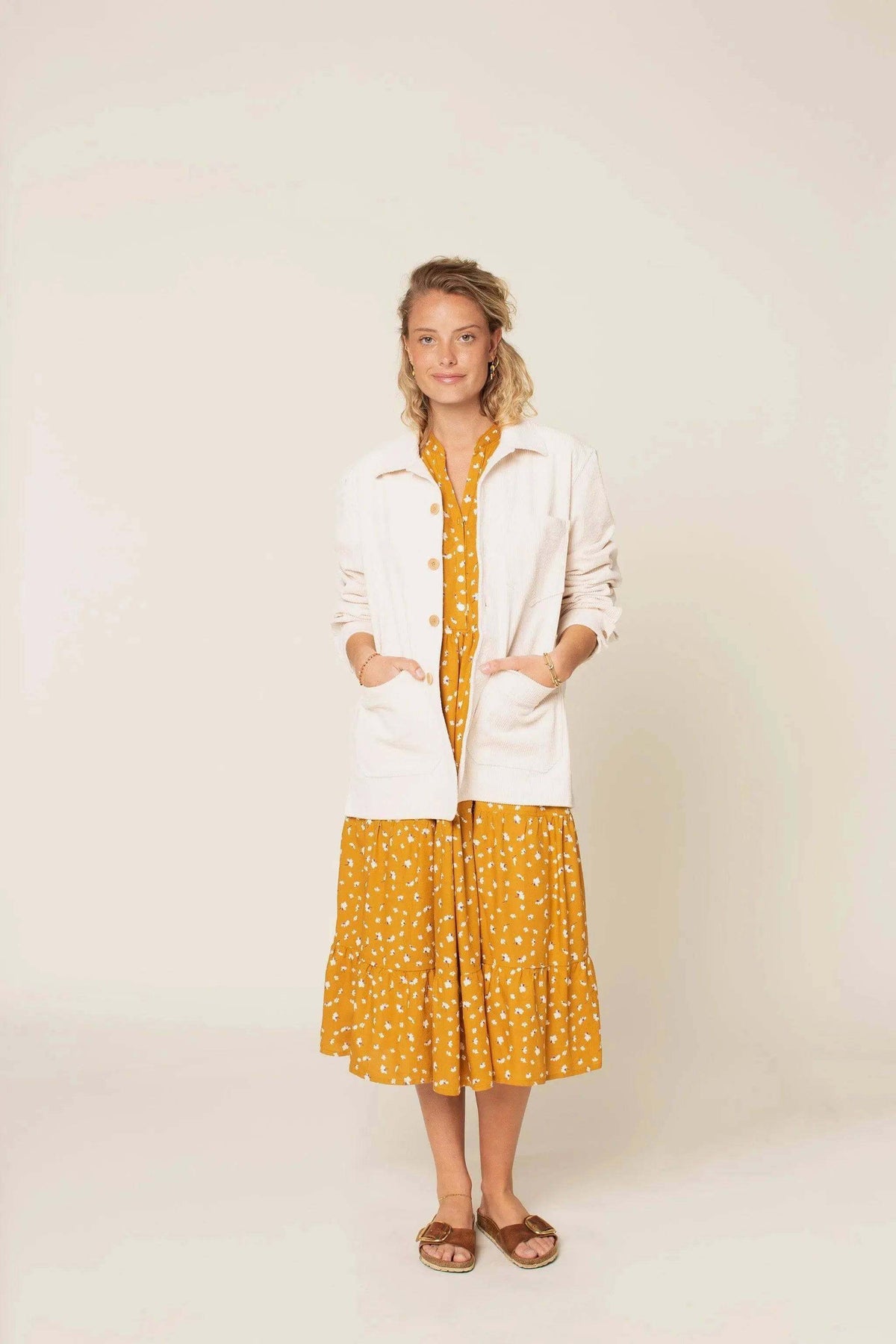 Woman wearing an Overshirt Jacket Paper Pattern over a mustard dress with white polka dots, featuring cuffed sleeves and patch pockets.