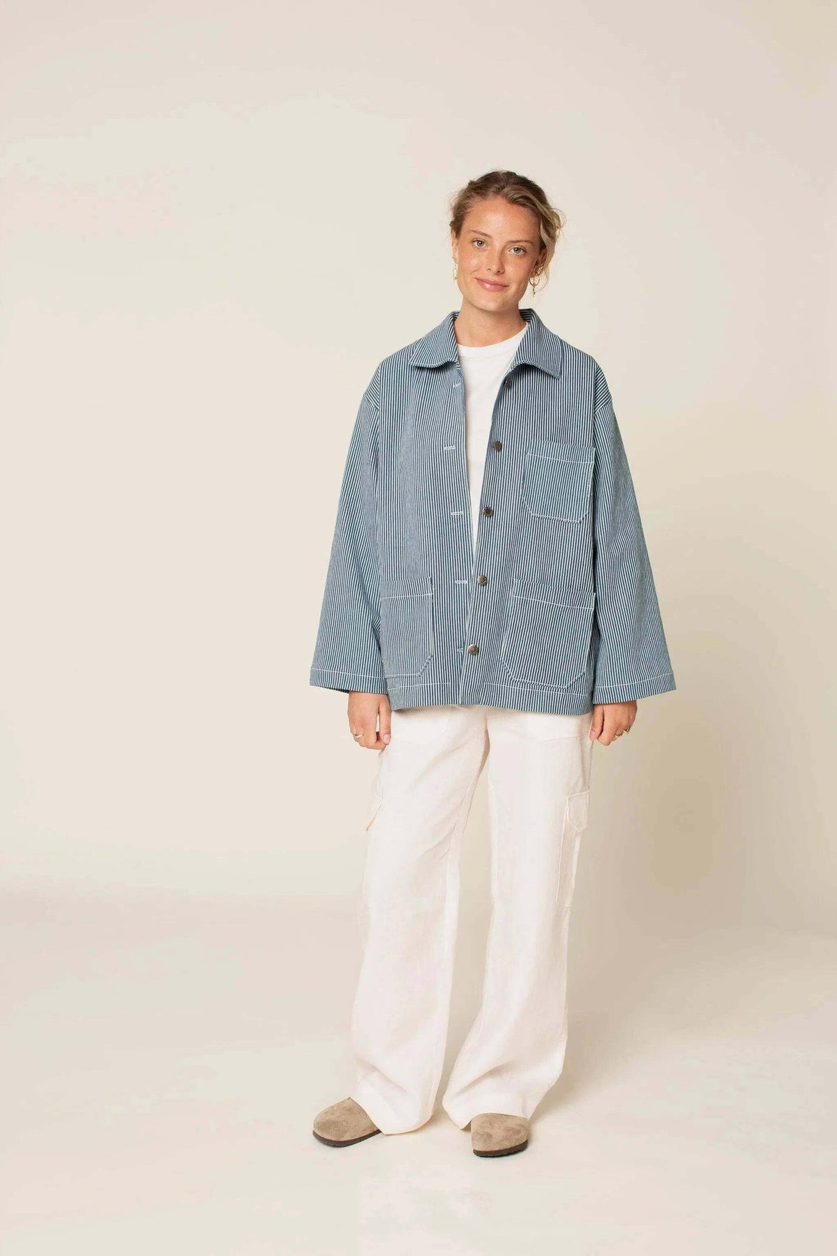 Model wearing a Painter jacket Paper Pattern, featuring an oversized fit and patch pockets, styled with white pants.