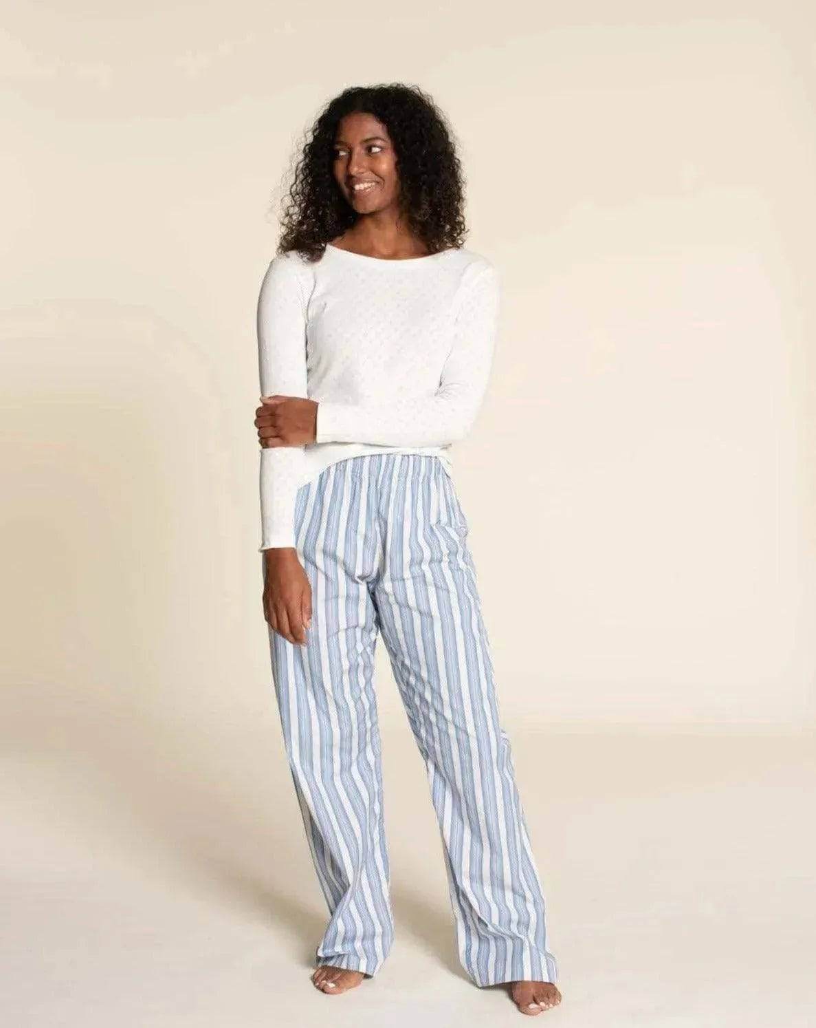 Model wearing Pajama Pants Paper Pattern with a white top and blue striped pajama pants, showcasing a loose-fit design.