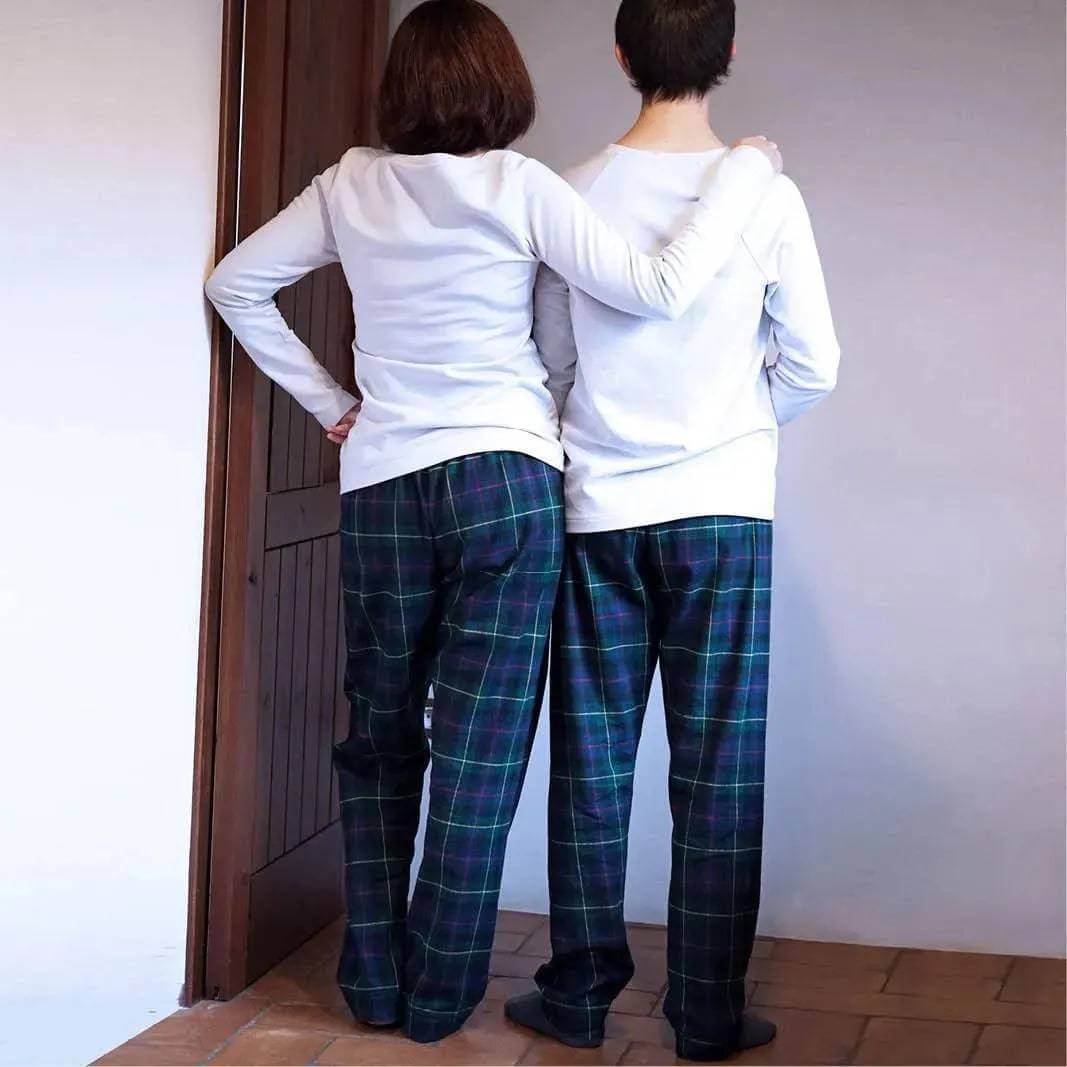Pajama Pants Paper Pattern shown on two people wearing comfortable plaid pajama pants in a cozy setting.