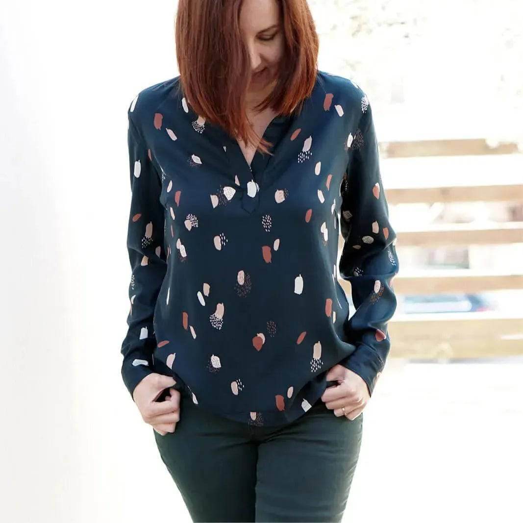Woman wearing a stylish navy blouse with colorful patterns, showcasing the Perfect Tunic Paper Pattern design.