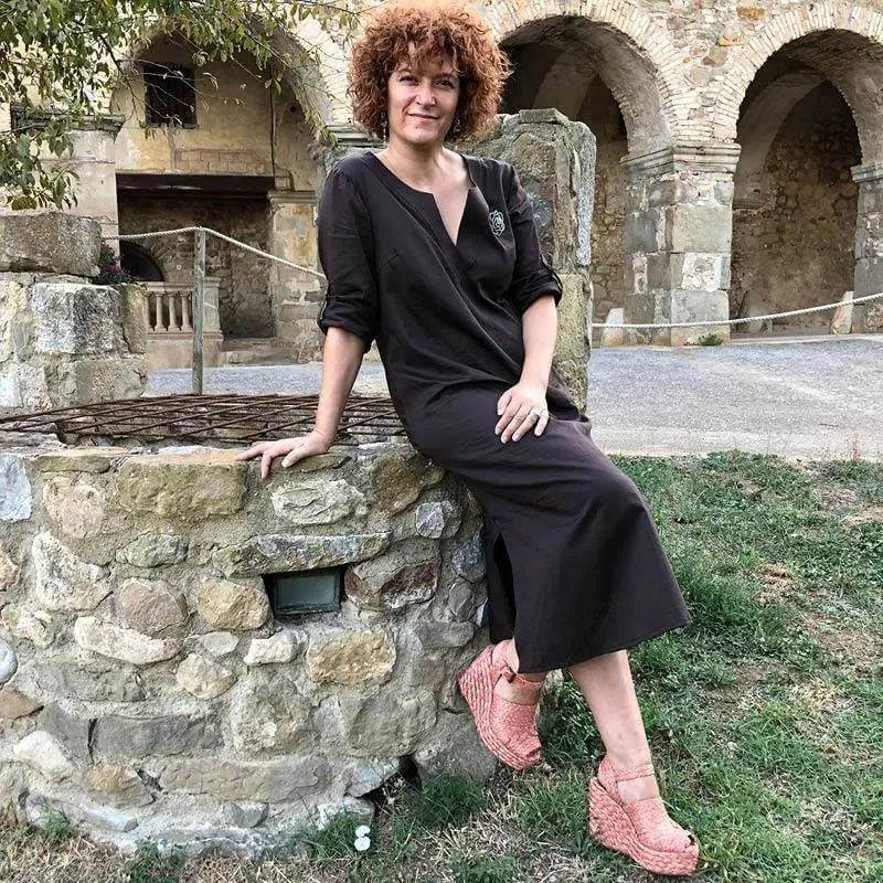 Woman posing in a stylish black Piper Tunic Paper Pattern in a scenic outdoor setting.