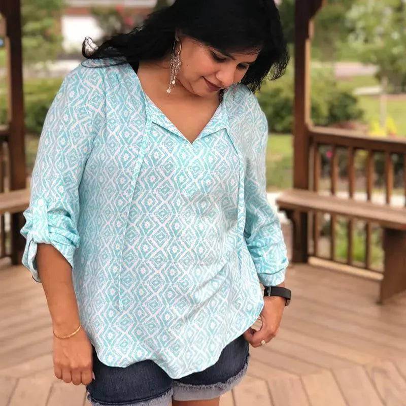 Piper Tunic Paper Pattern women wearing a stylish light blue tunic with rolled-up sleeves and a relaxed fit.