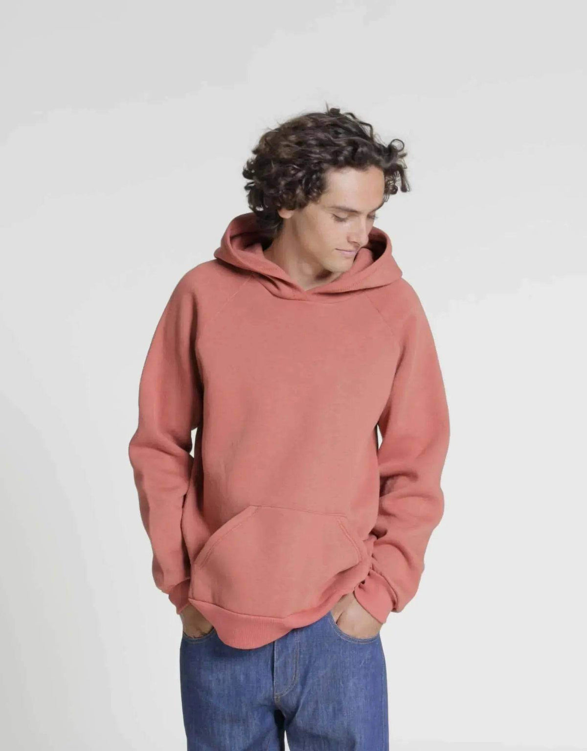 Rebel Hoodie paper pattern model wearing a relaxed fit hoodie in a coral color with a kangaroo pocket.