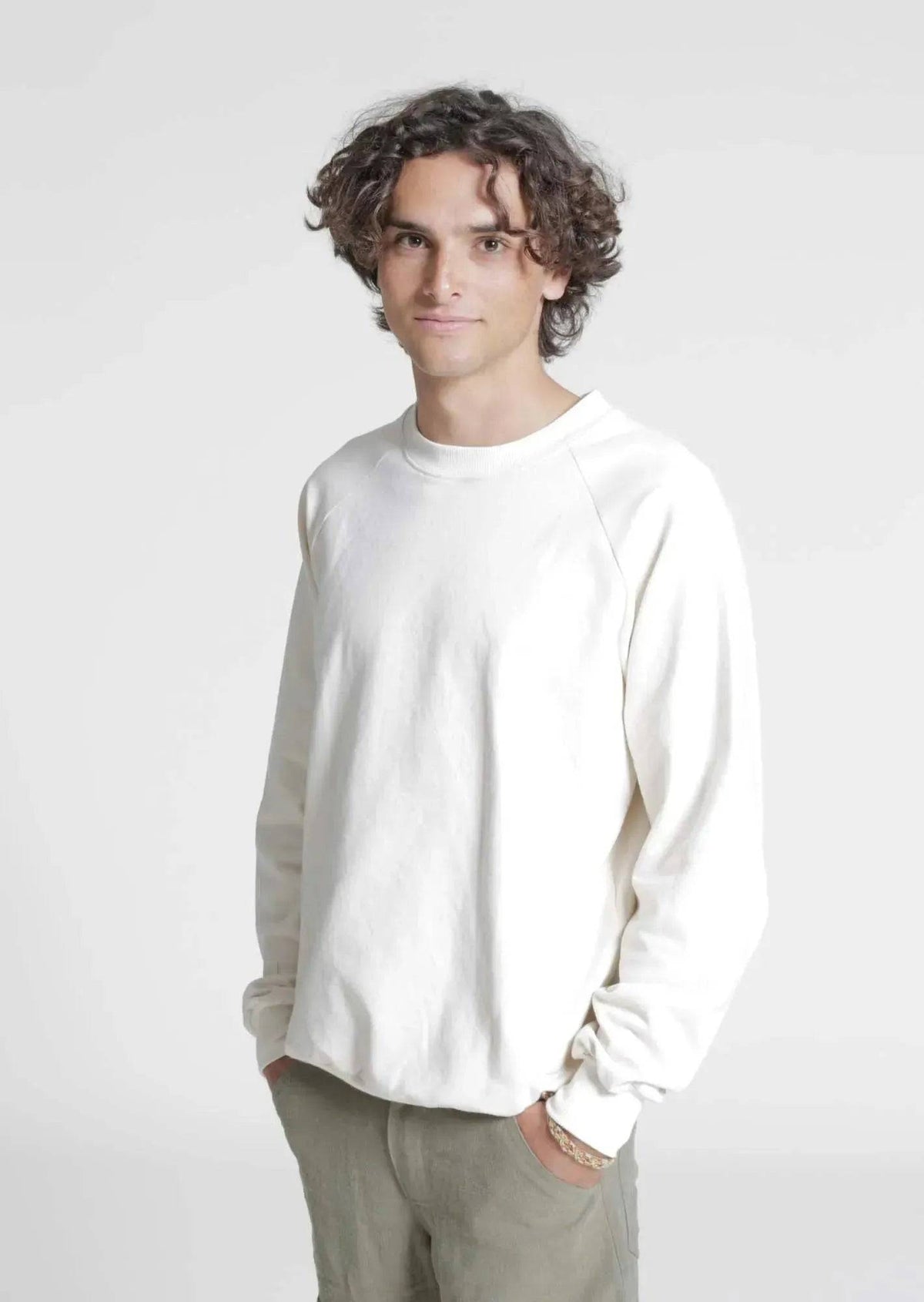 A young man wearing a relaxed fit cream Rebel Hoodie paper pattern sweatshirt, showcasing casual style and comfort.