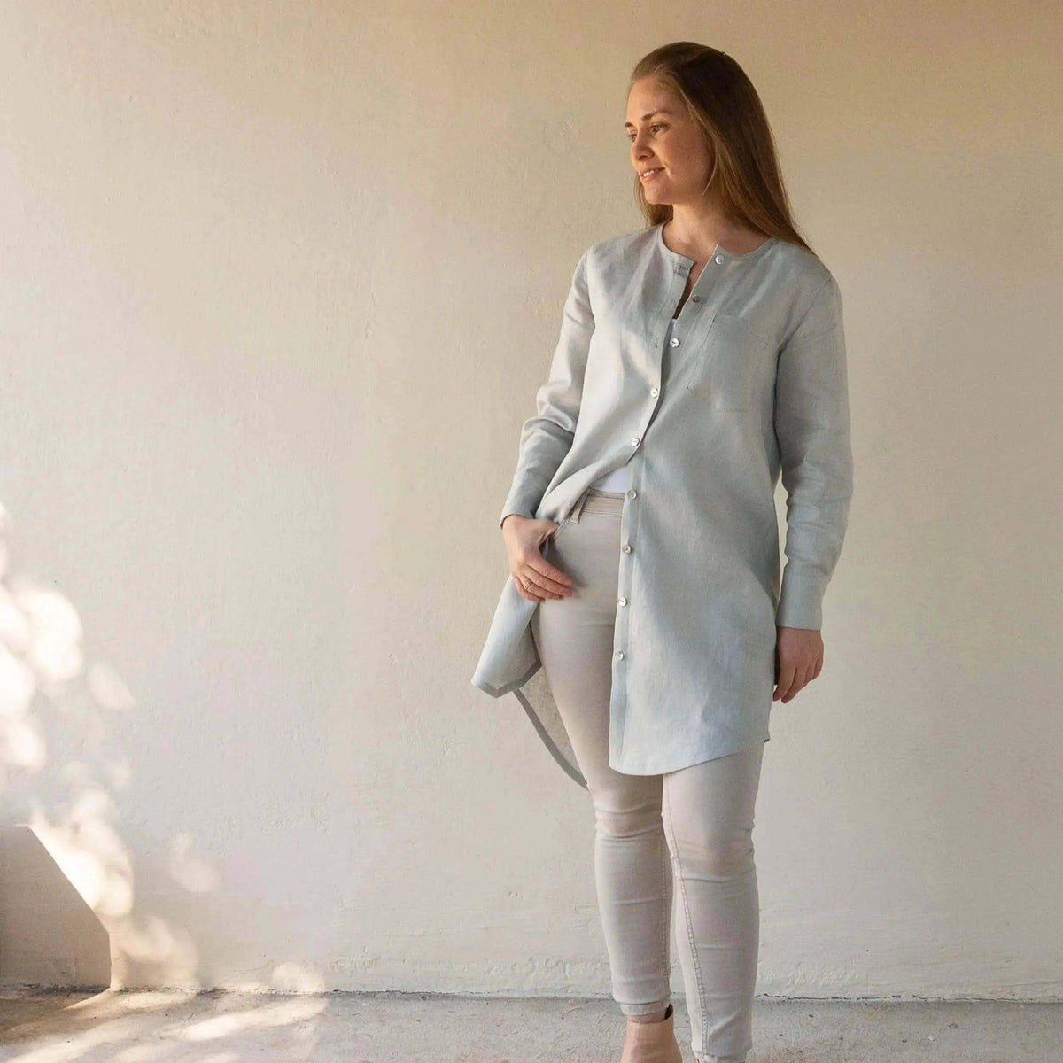 Woman modeling the Savannah shirt Paper Pattern in light blue, showcasing its elegant design and versatility.