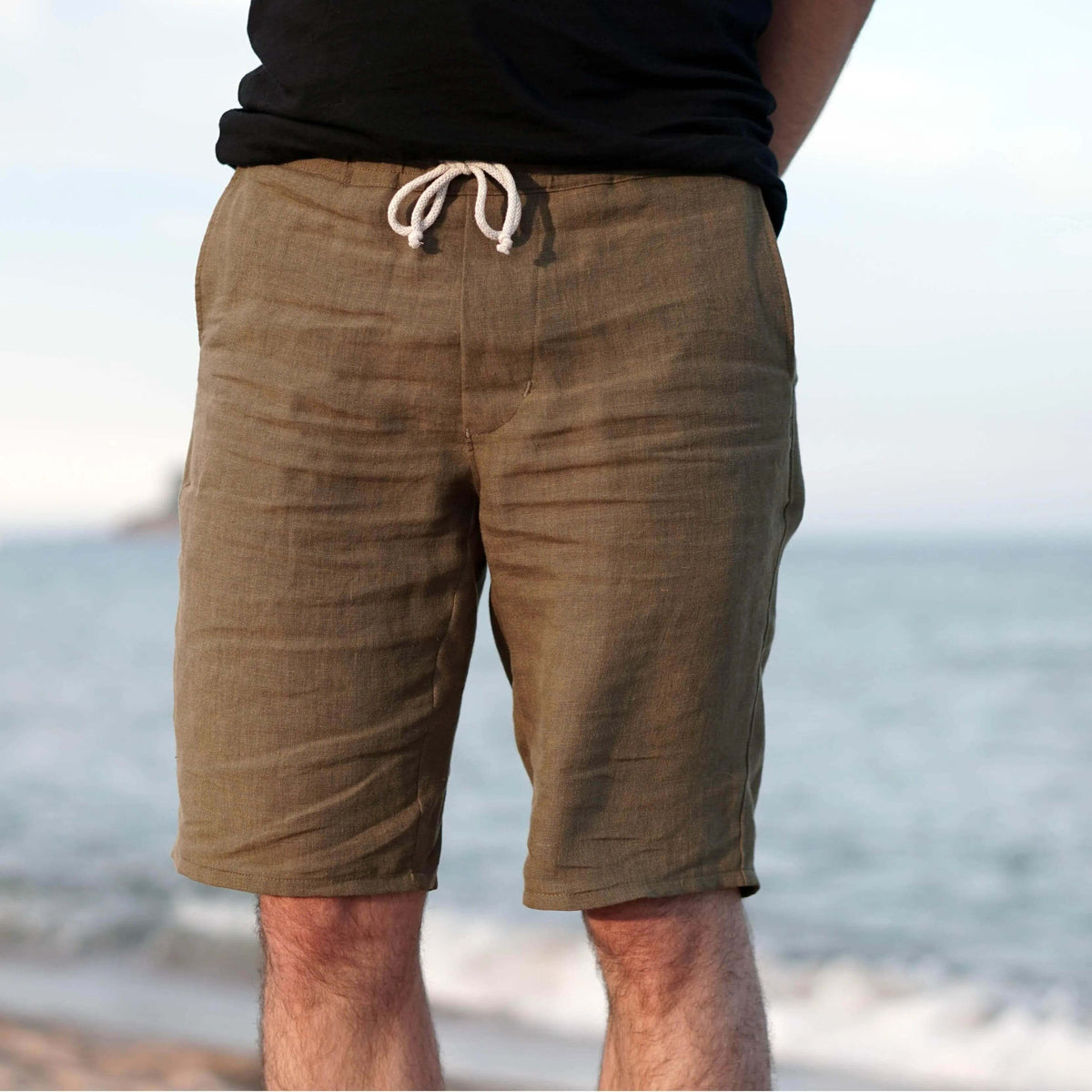 Men wearing summer pants paper pattern, showcasing lightweight design and relaxed fit at the beach.