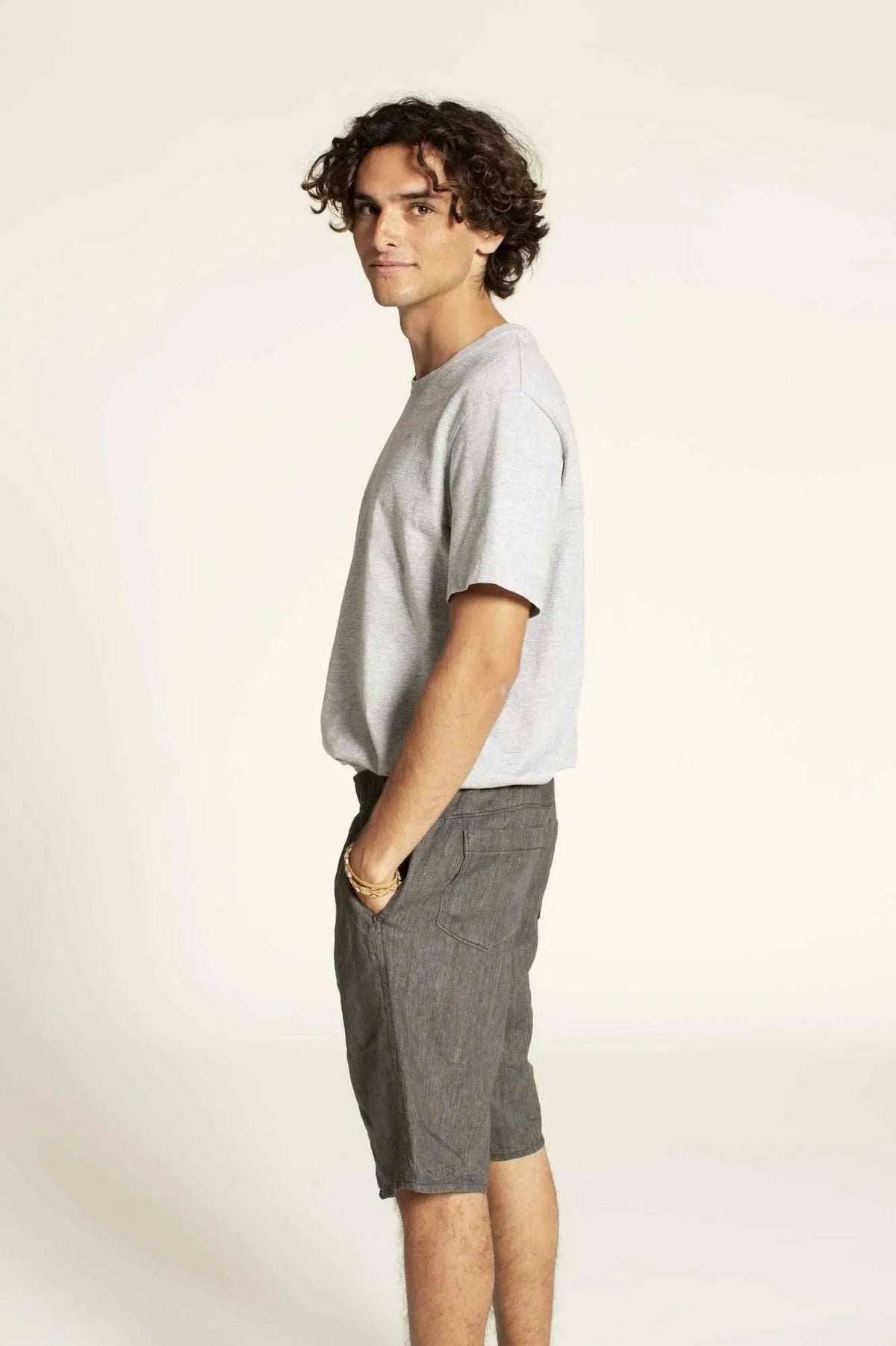 Summer pants paper pattern modeled by a man in a relaxed fit gray t-shirt and stylish shorts.