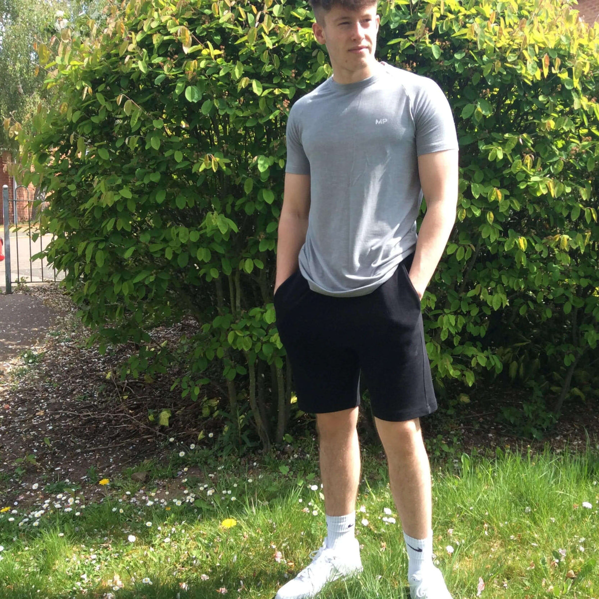 Model wearing casual outfit in a garden featuring Rebel Sweatpants Paper pattern